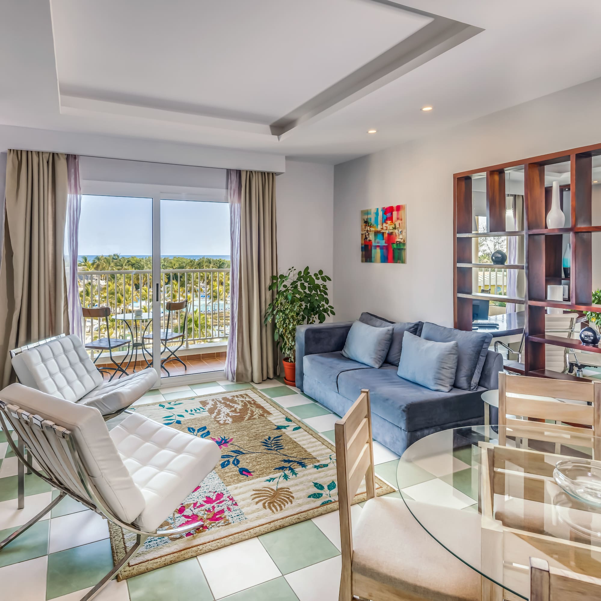 a living room with a glass table and chairs