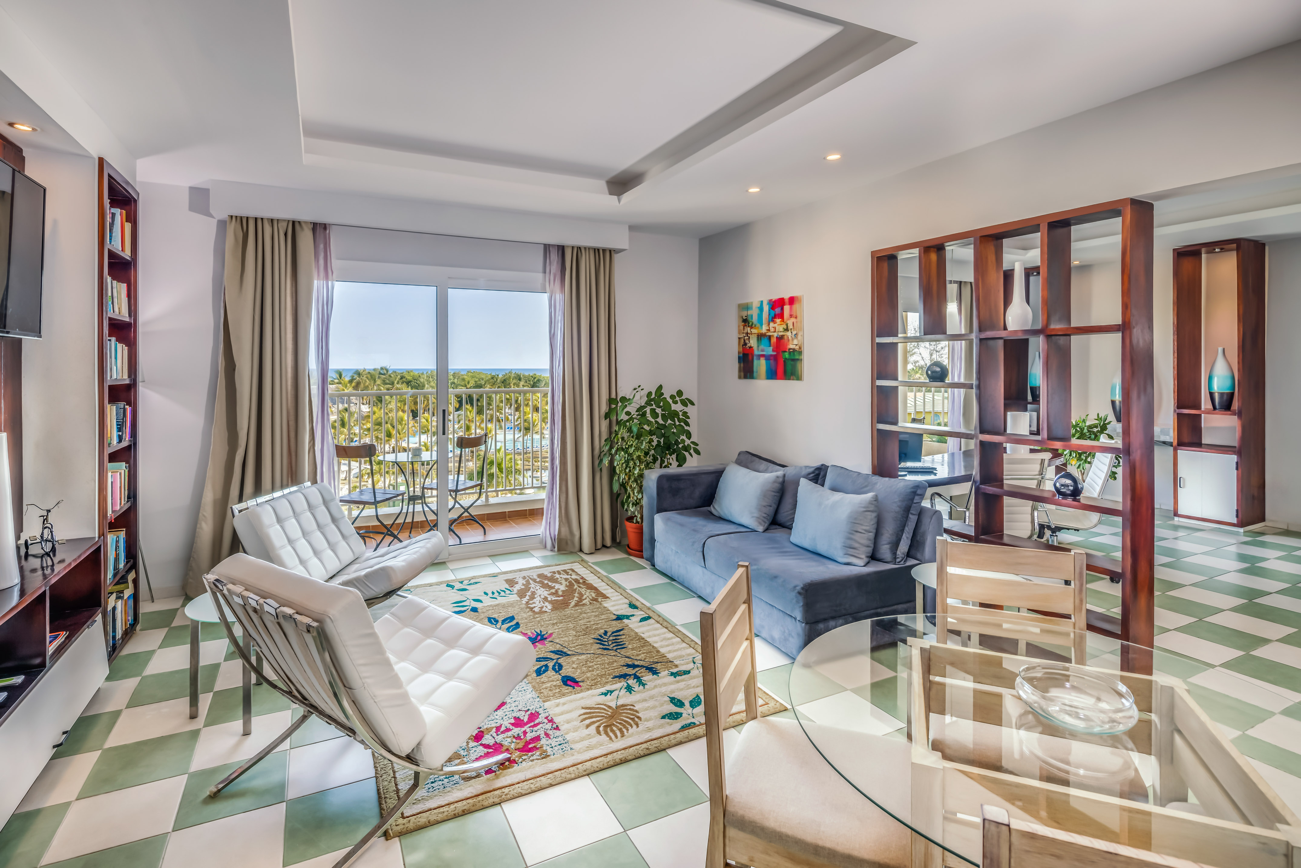 a living room with a glass table and chairs