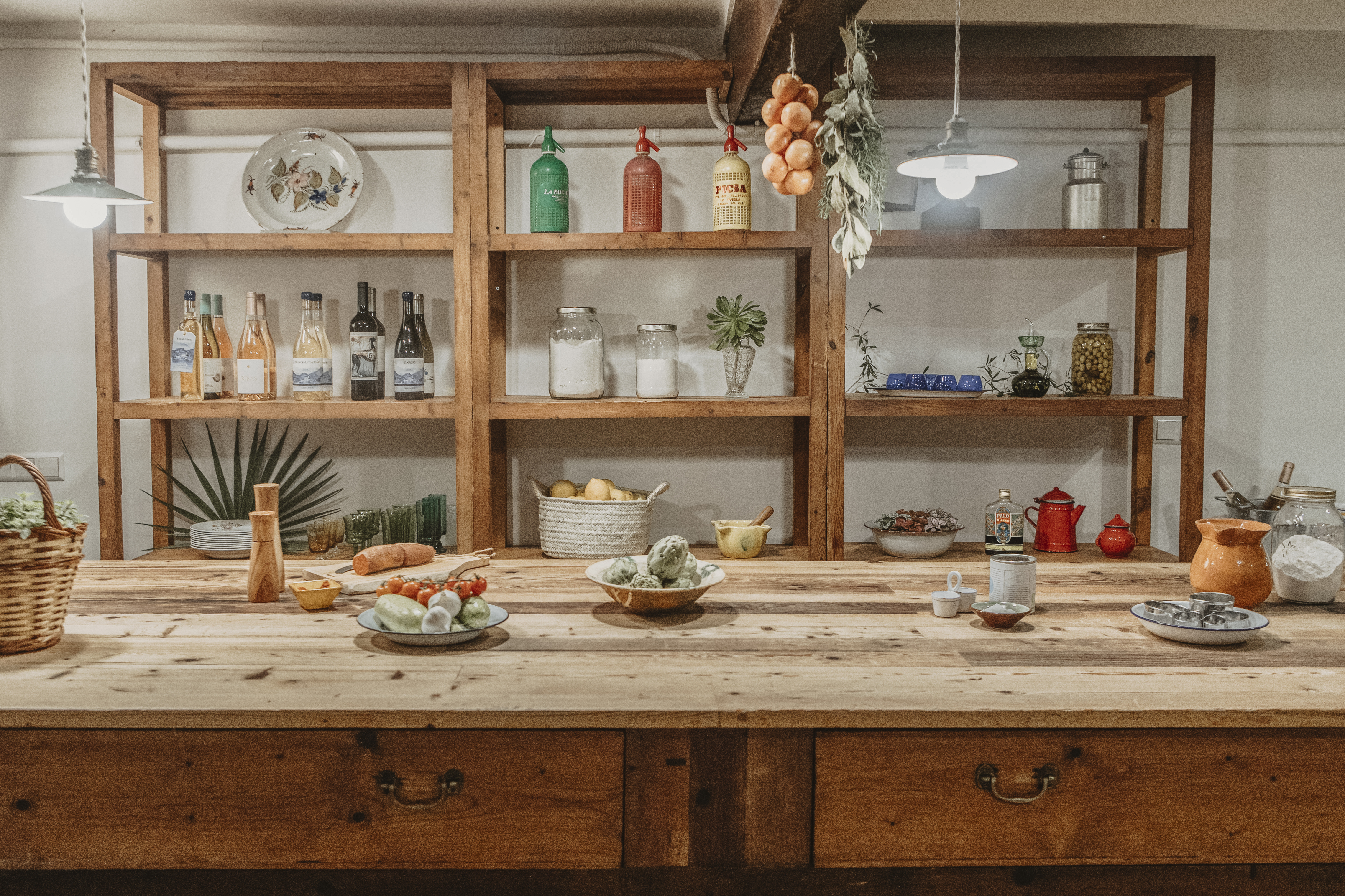 a kitchen with shelves and food on the counter