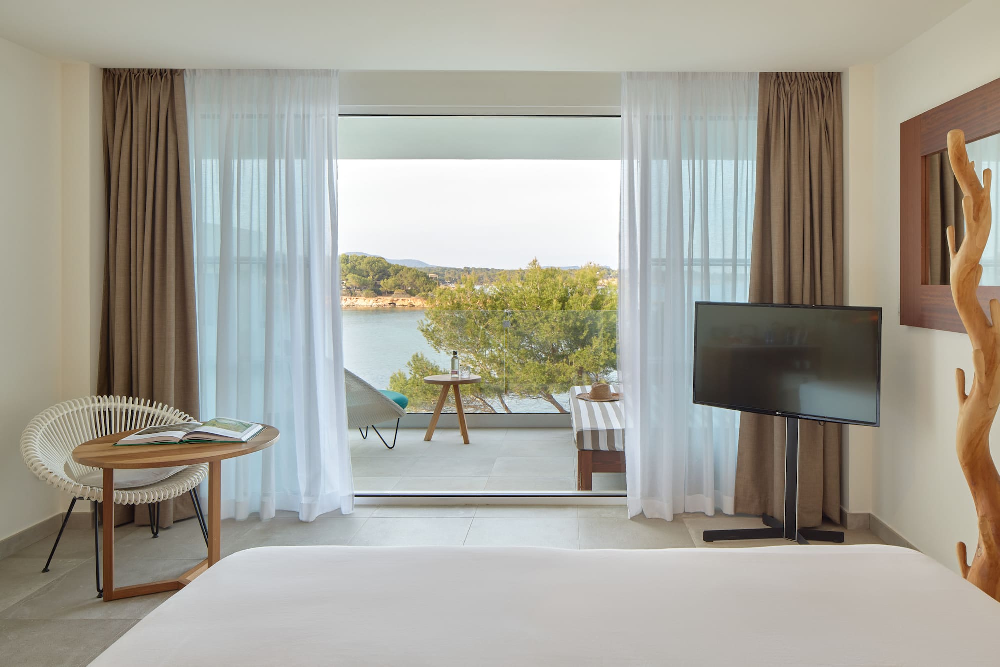 a room with a television and a view of the water