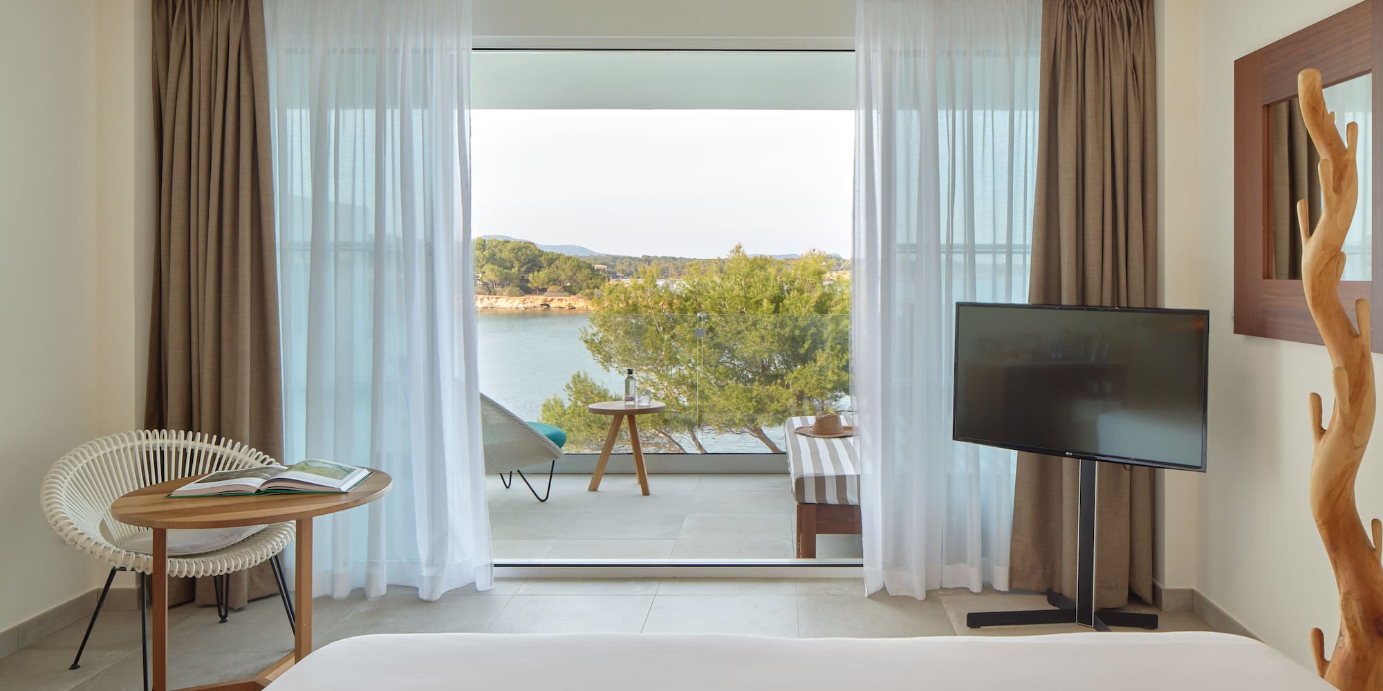 a room with a television and a view of the water