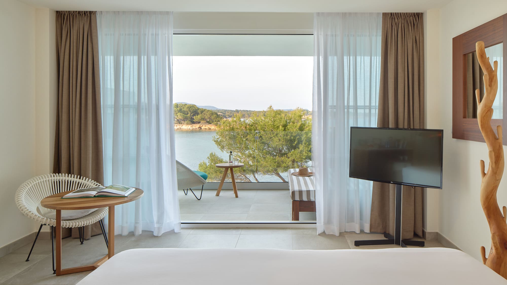 a room with a television and a view of the water