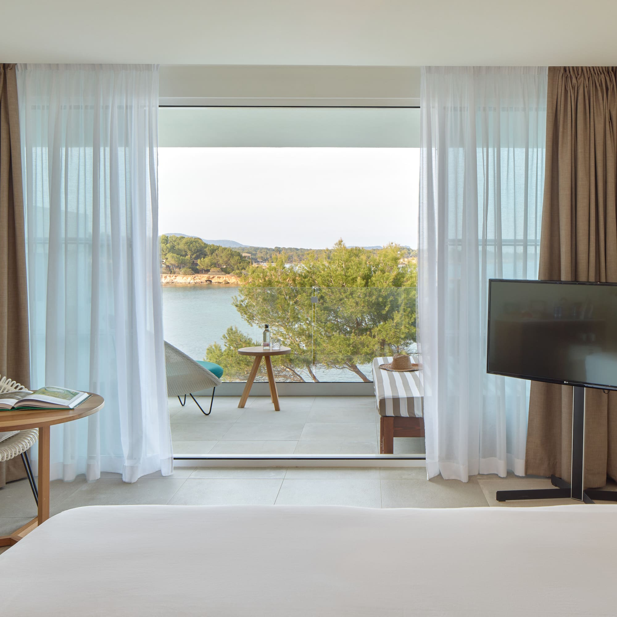 a room with a television and a view of the water