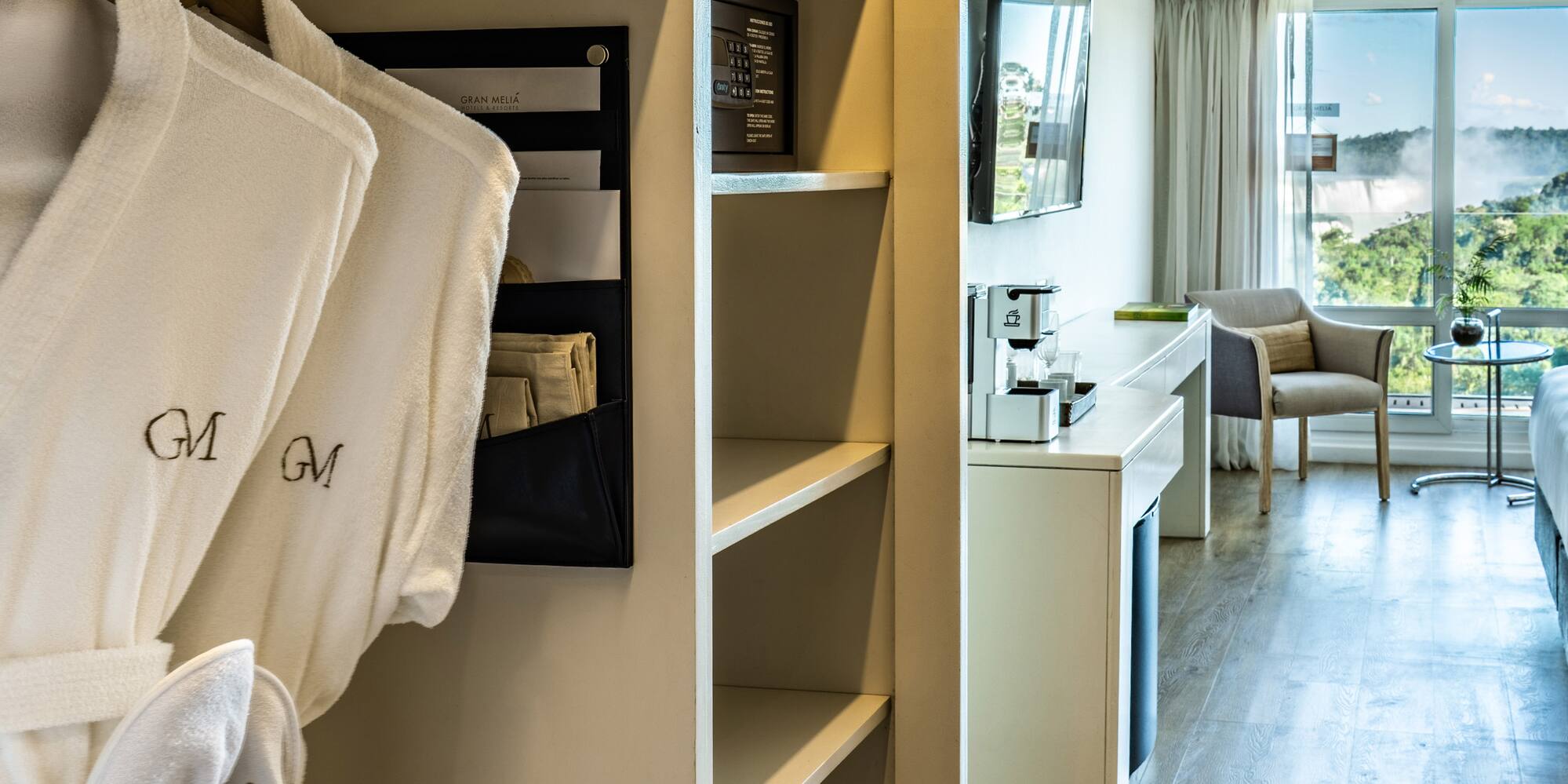 a room with white bathrobes and a bed and a television