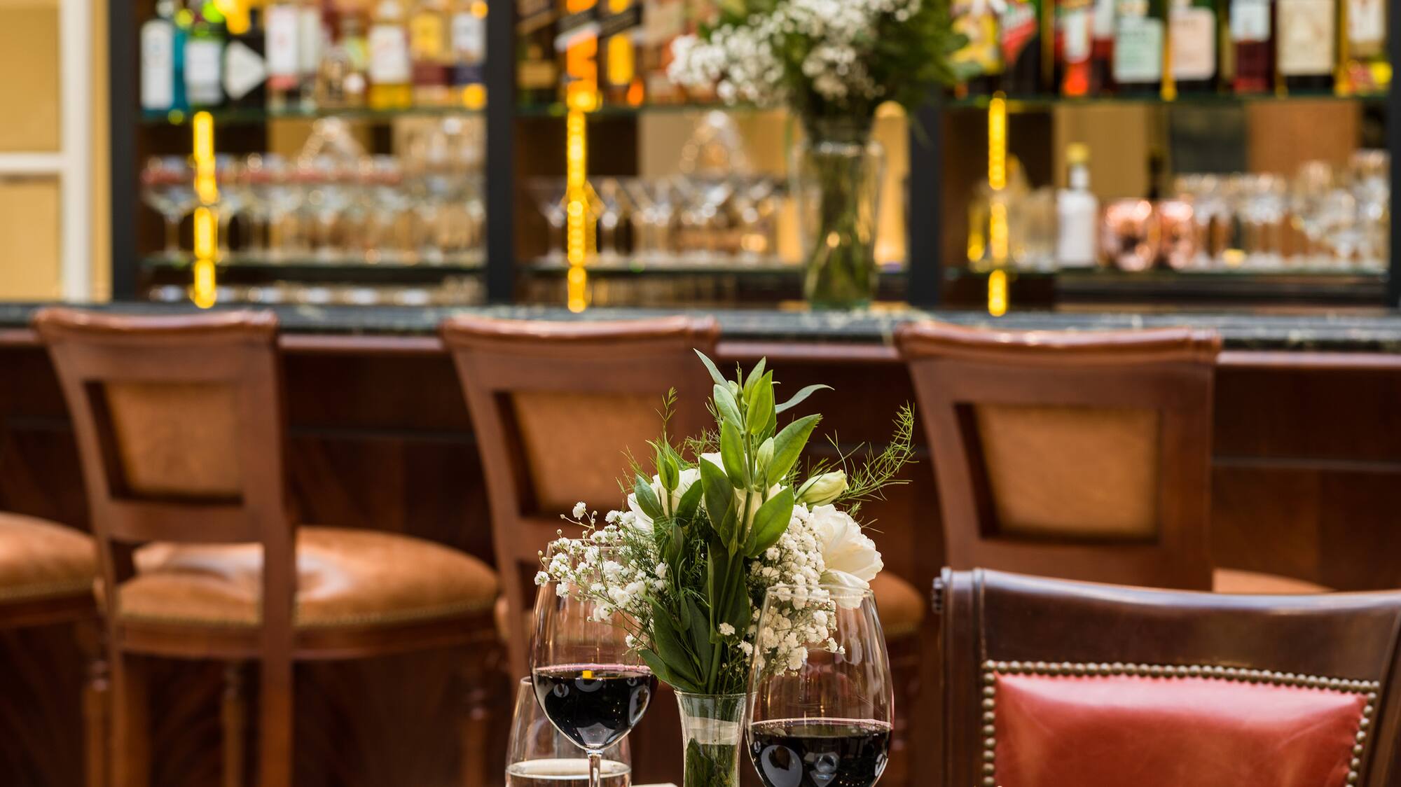 a table with food and wine glasses in front of a bar