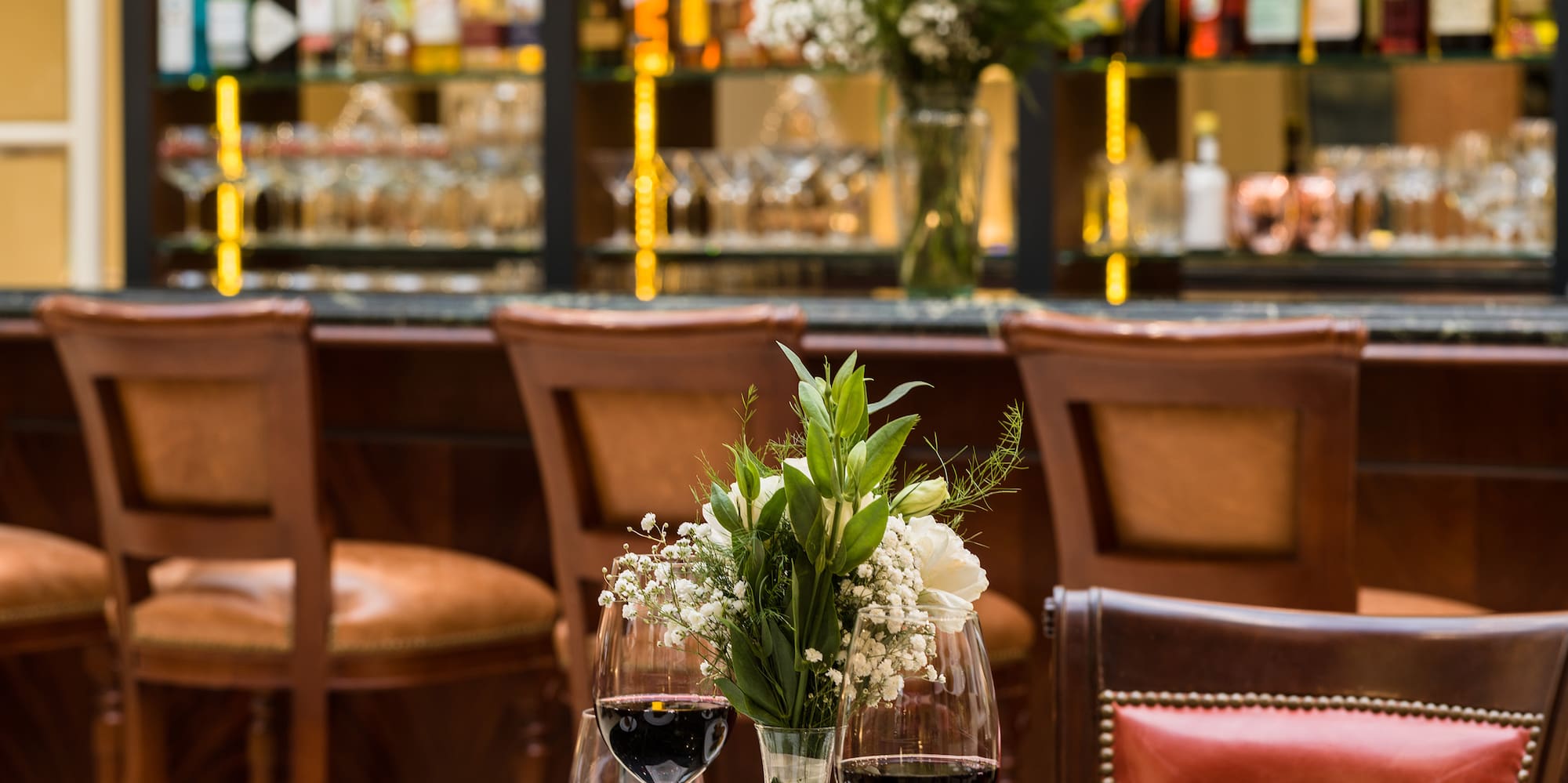 a table with food and wine glasses in front of a bar