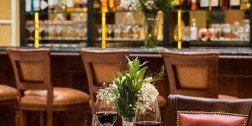 a table with food and wine glasses in front of a bar