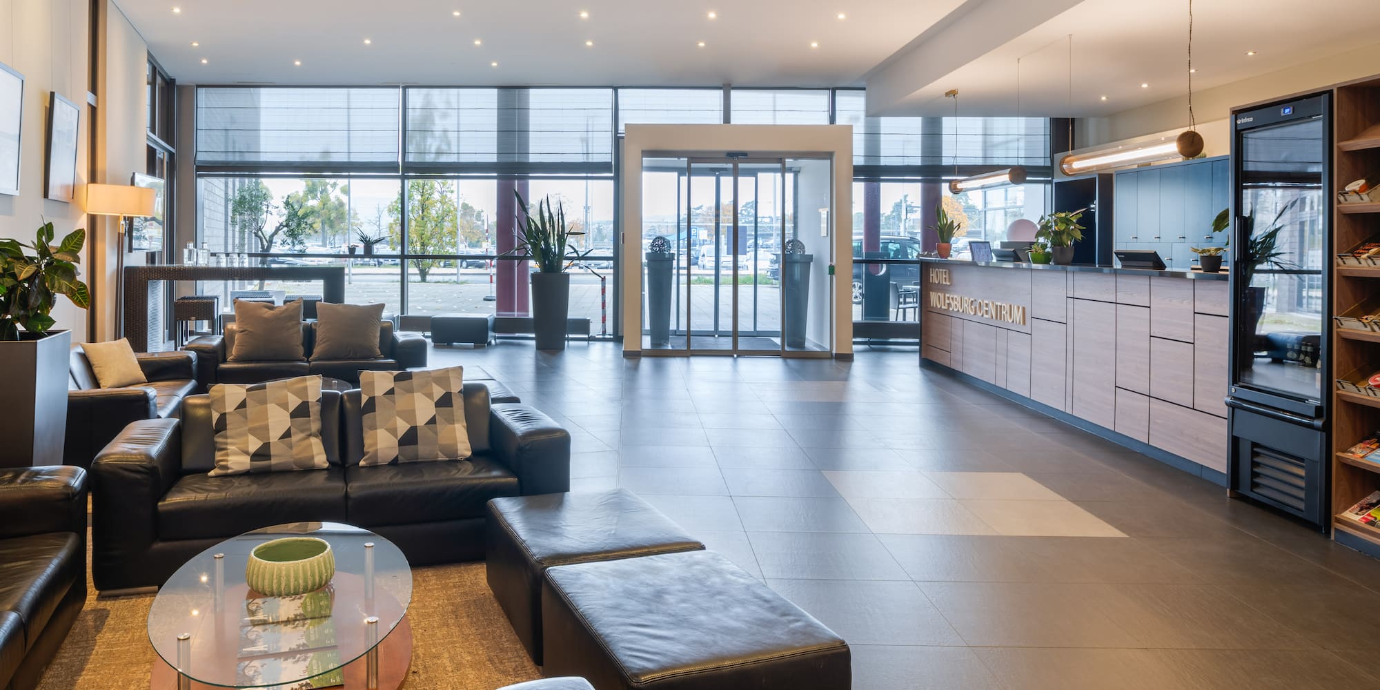 a lobby with a large glass door and a couch
