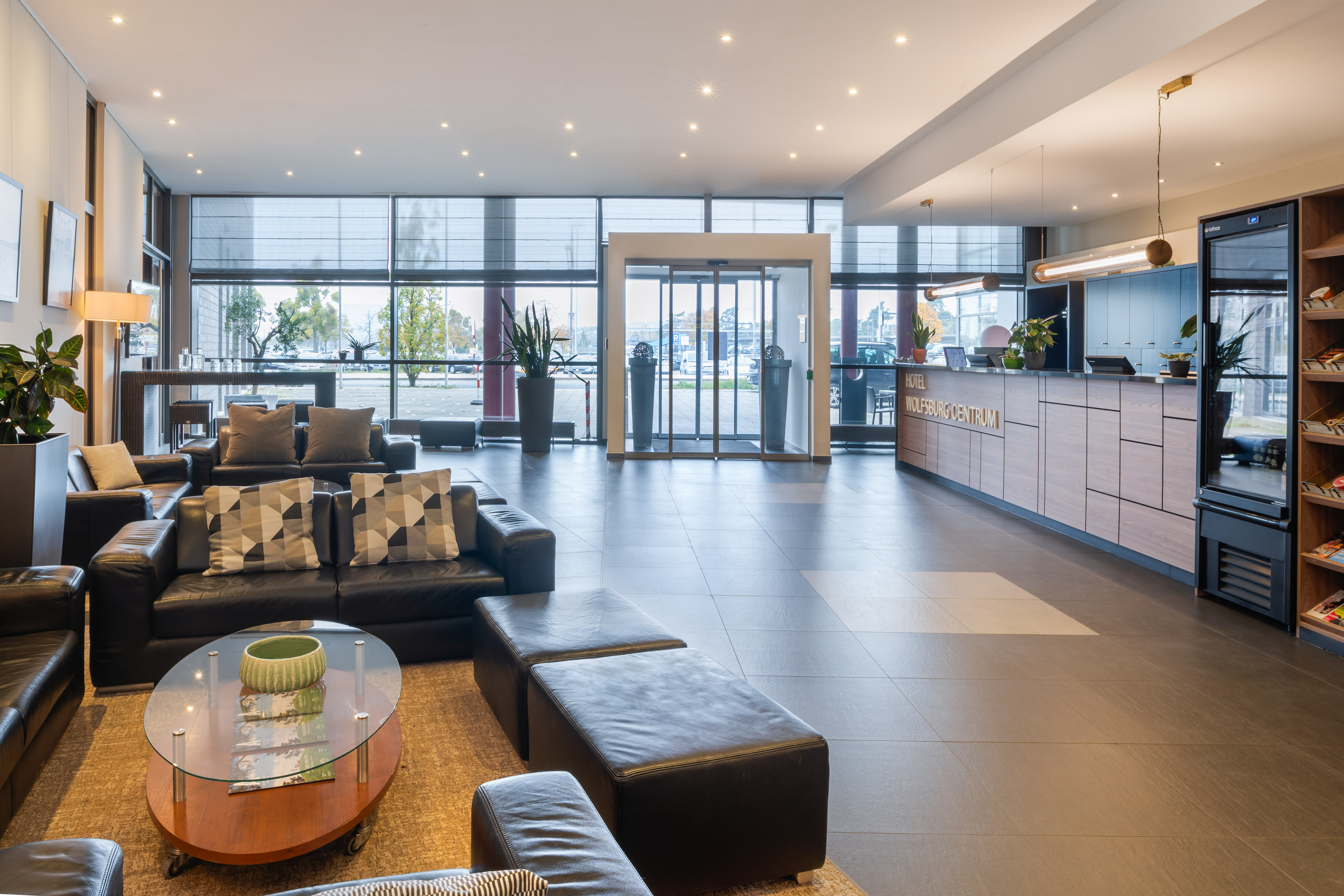 a lobby with a large glass door and a couch
