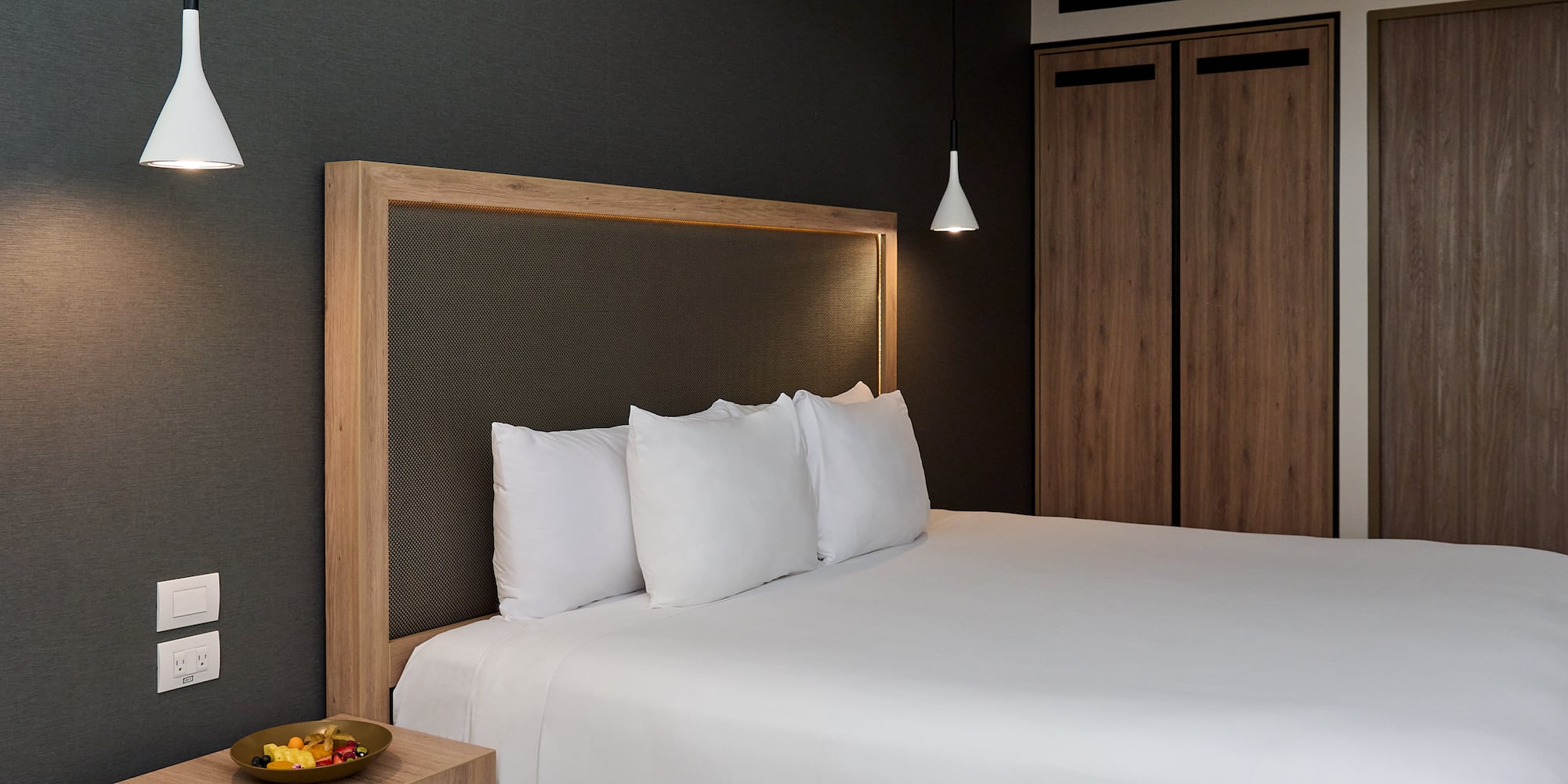 a bed with white sheets and a wooden headboard