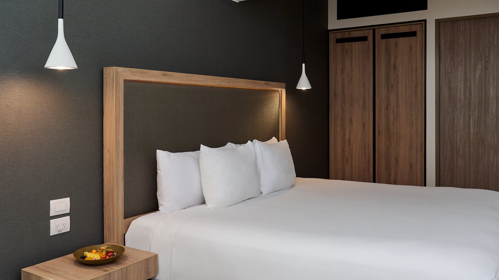 a bed with white sheets and a wooden headboard