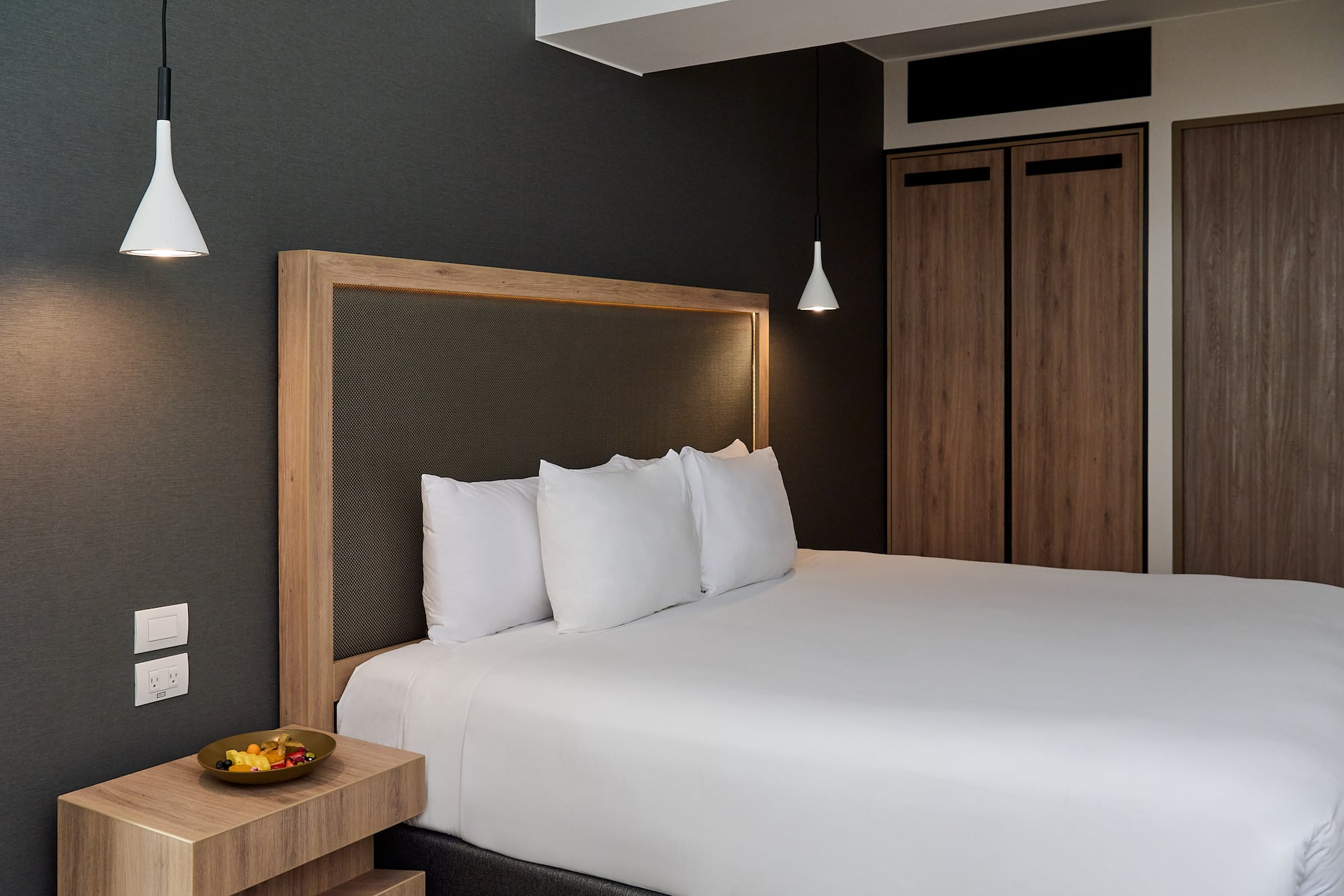 a bed with white sheets and a wooden headboard