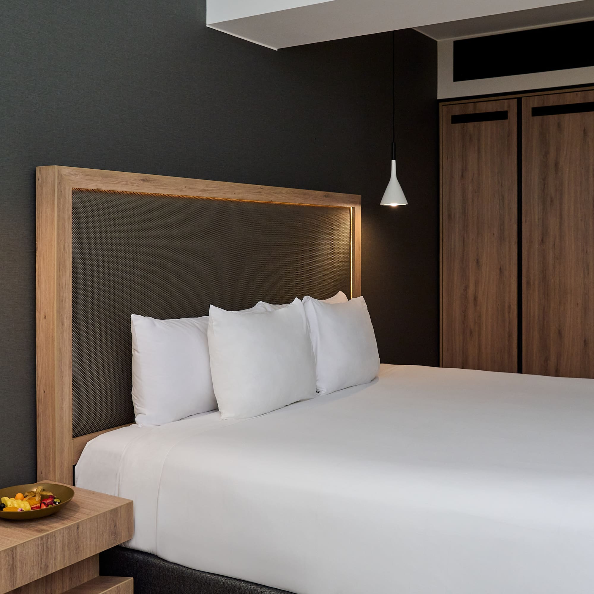 a bed with white sheets and a wooden headboard