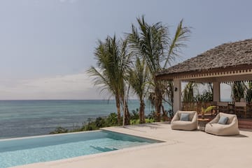 a swimming pool with a deck and chairs by it