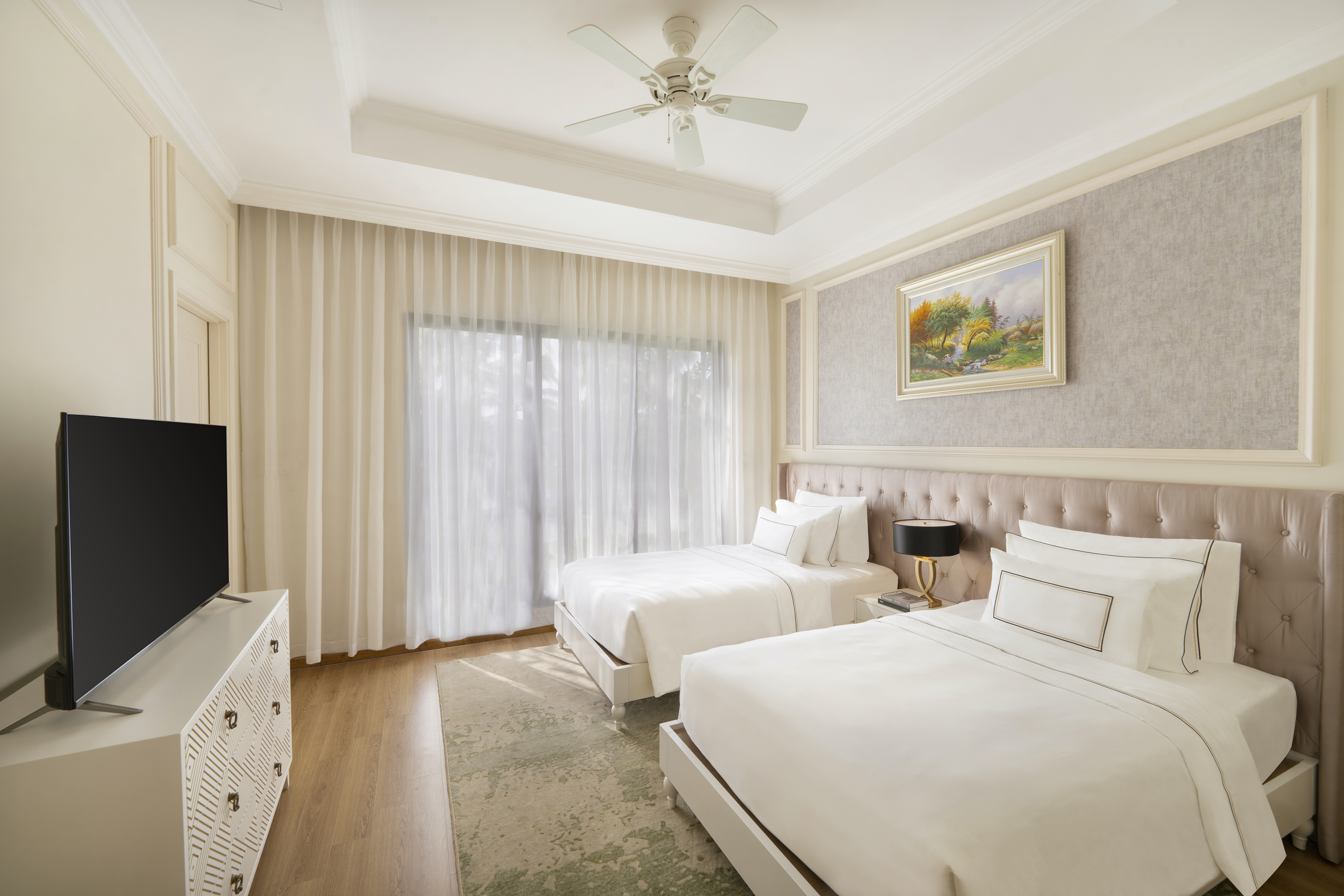 Modern hotel guest room with two twin beds, white bedding, TV, sheer curtains.