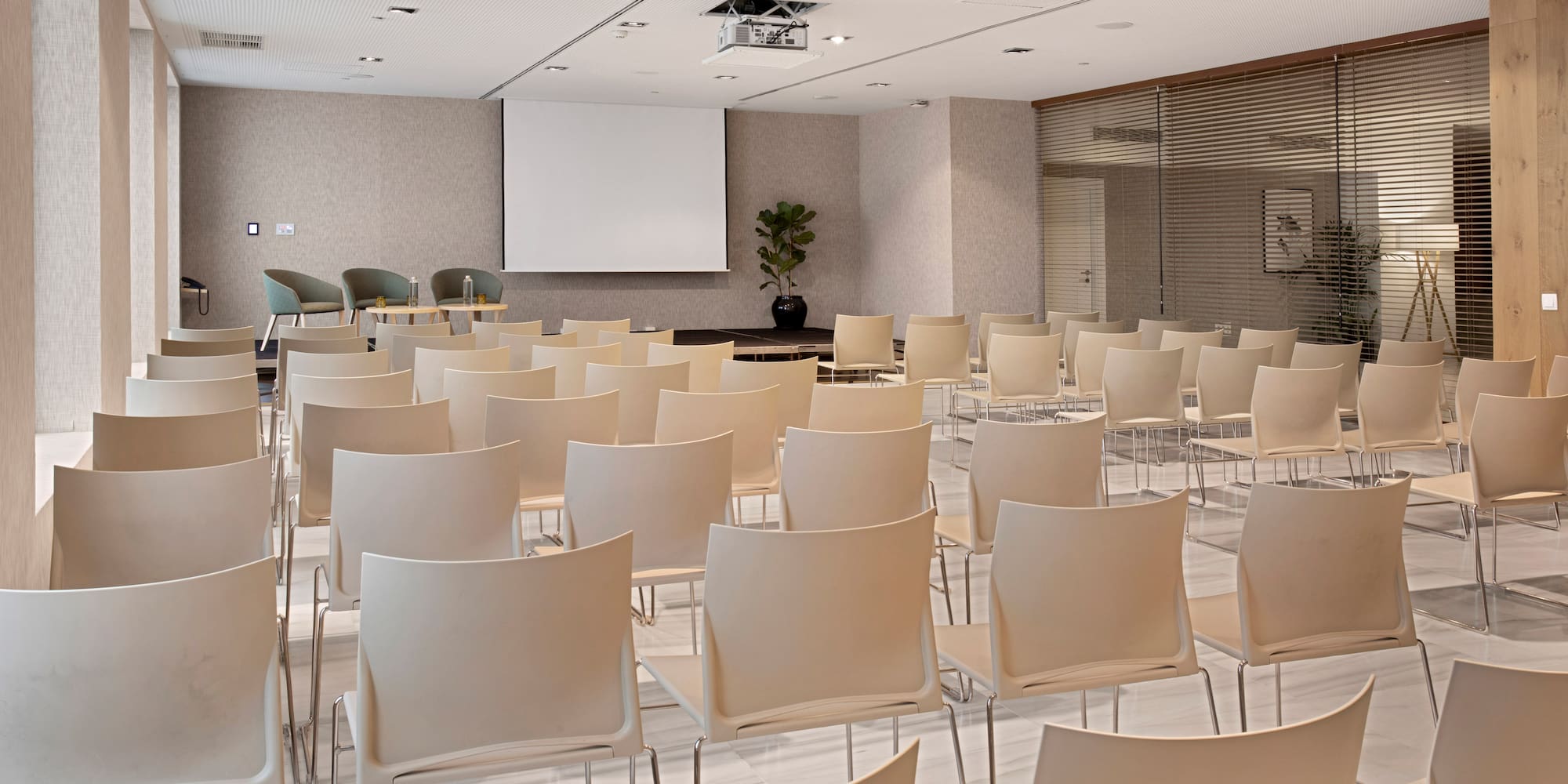 a room with white chairs and a projector screen