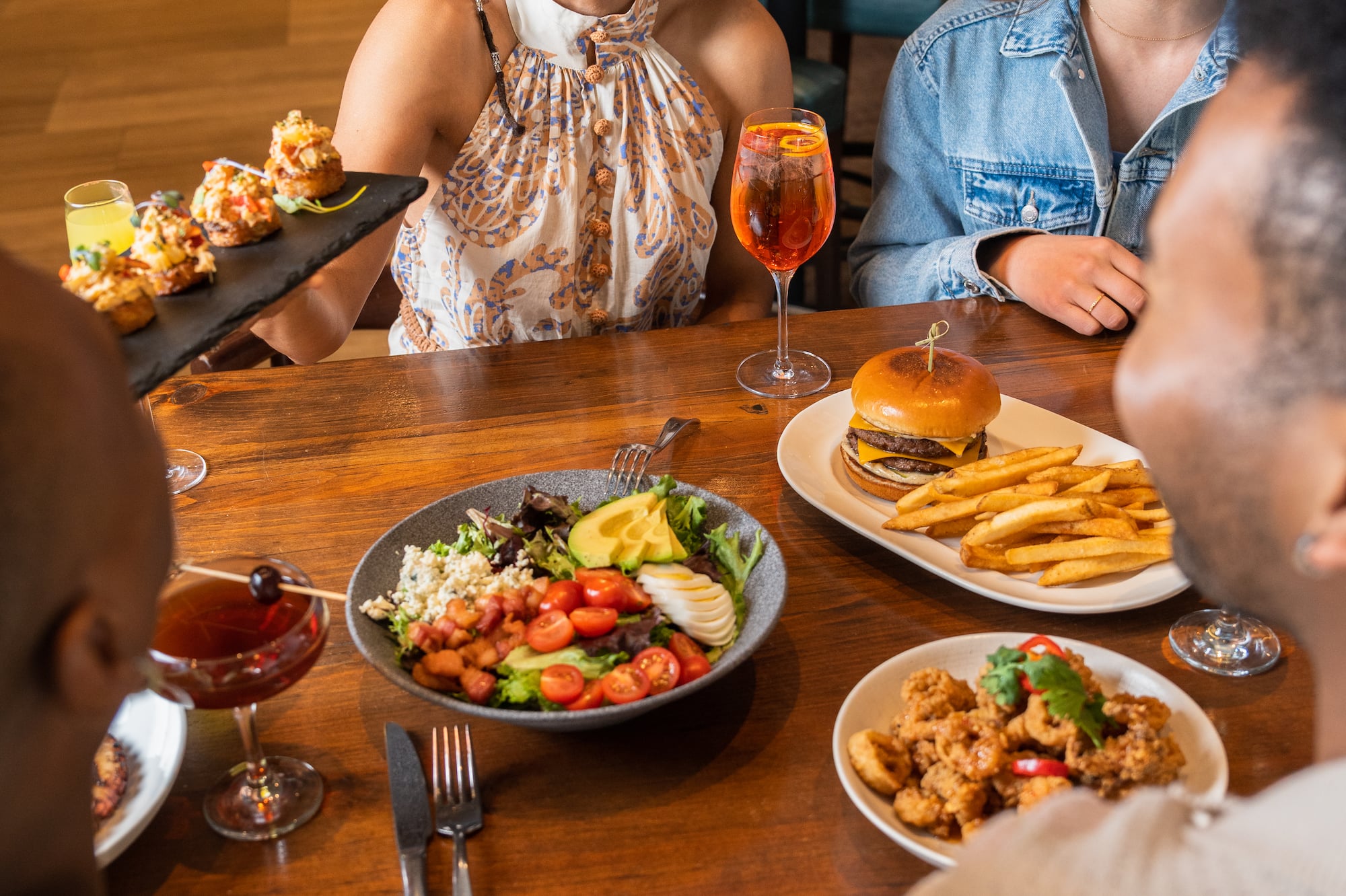 a group of people sitting at a table with food