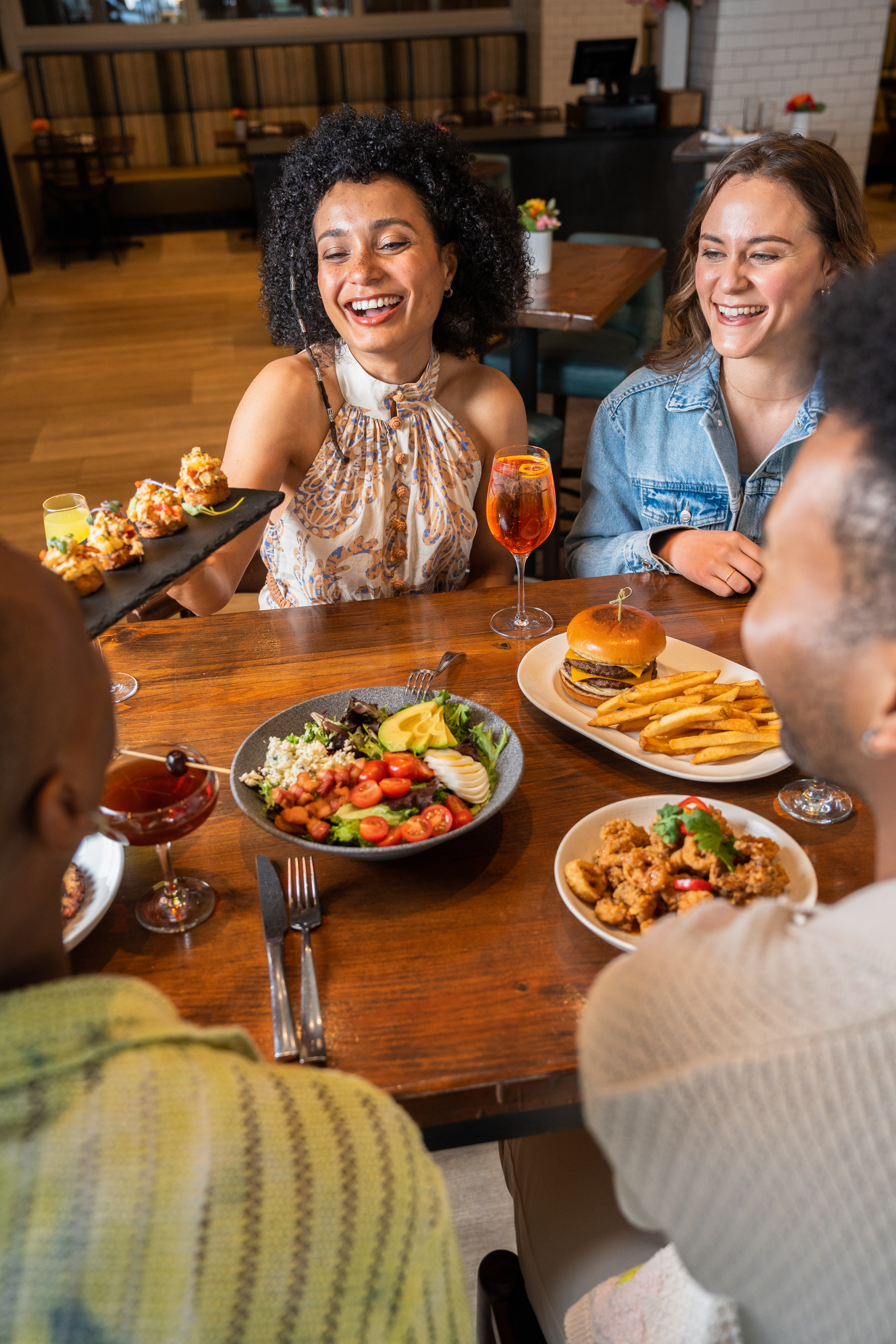 a group of people sitting at a table with food