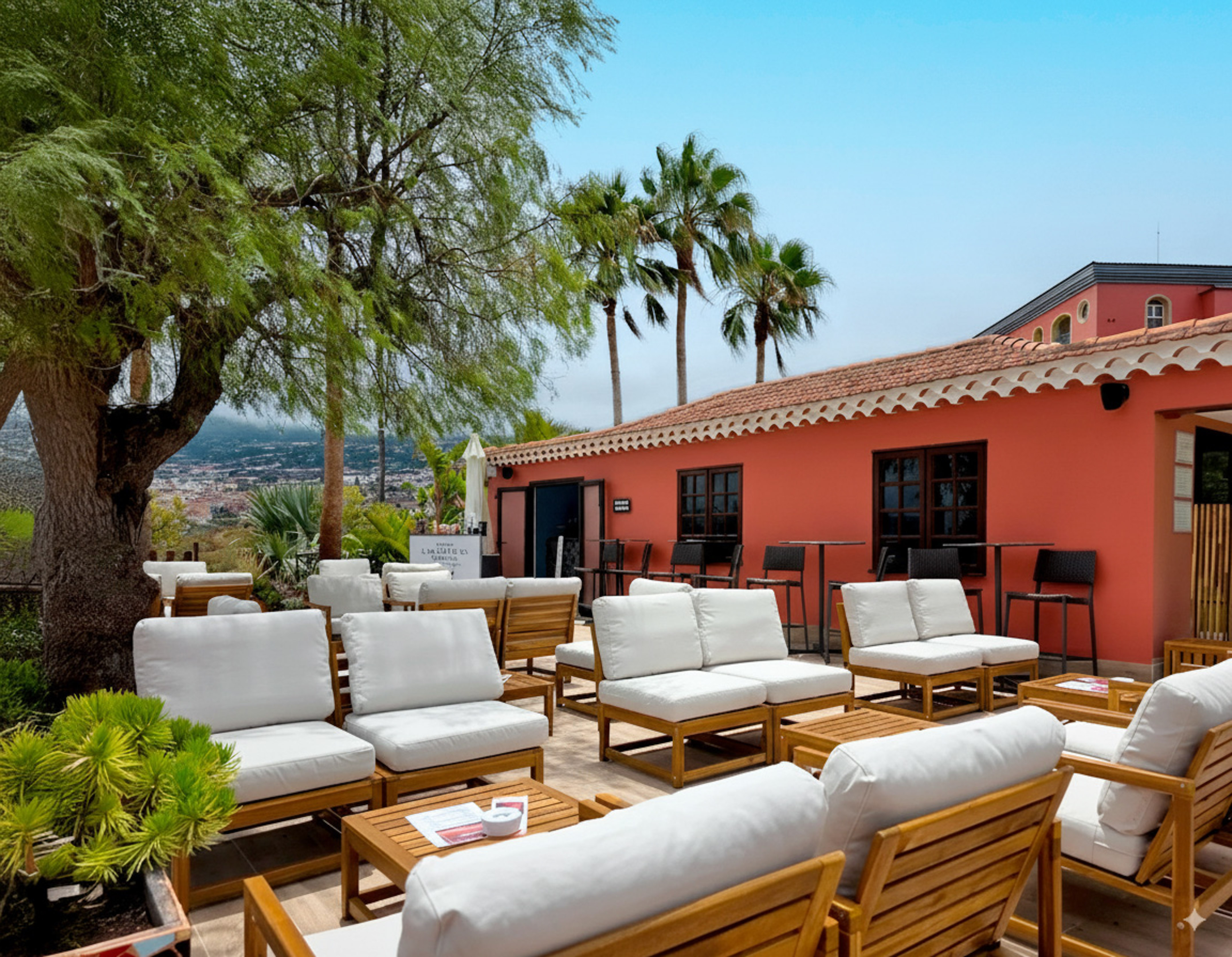 Tropical outdoor lounge patio with white seating, coral building, and palm trees.