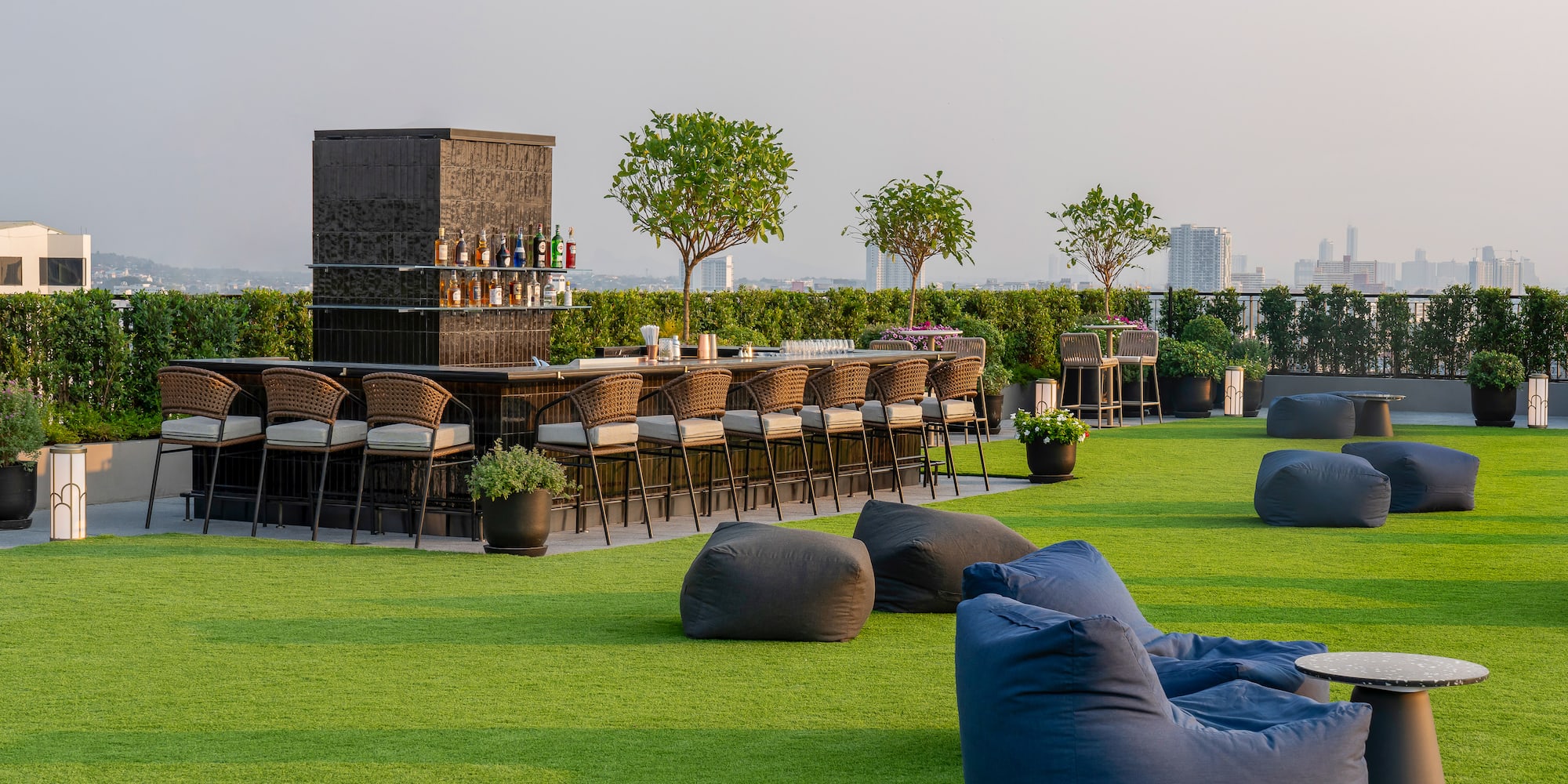 a group of chairs on a green lawn with a bar and a bench