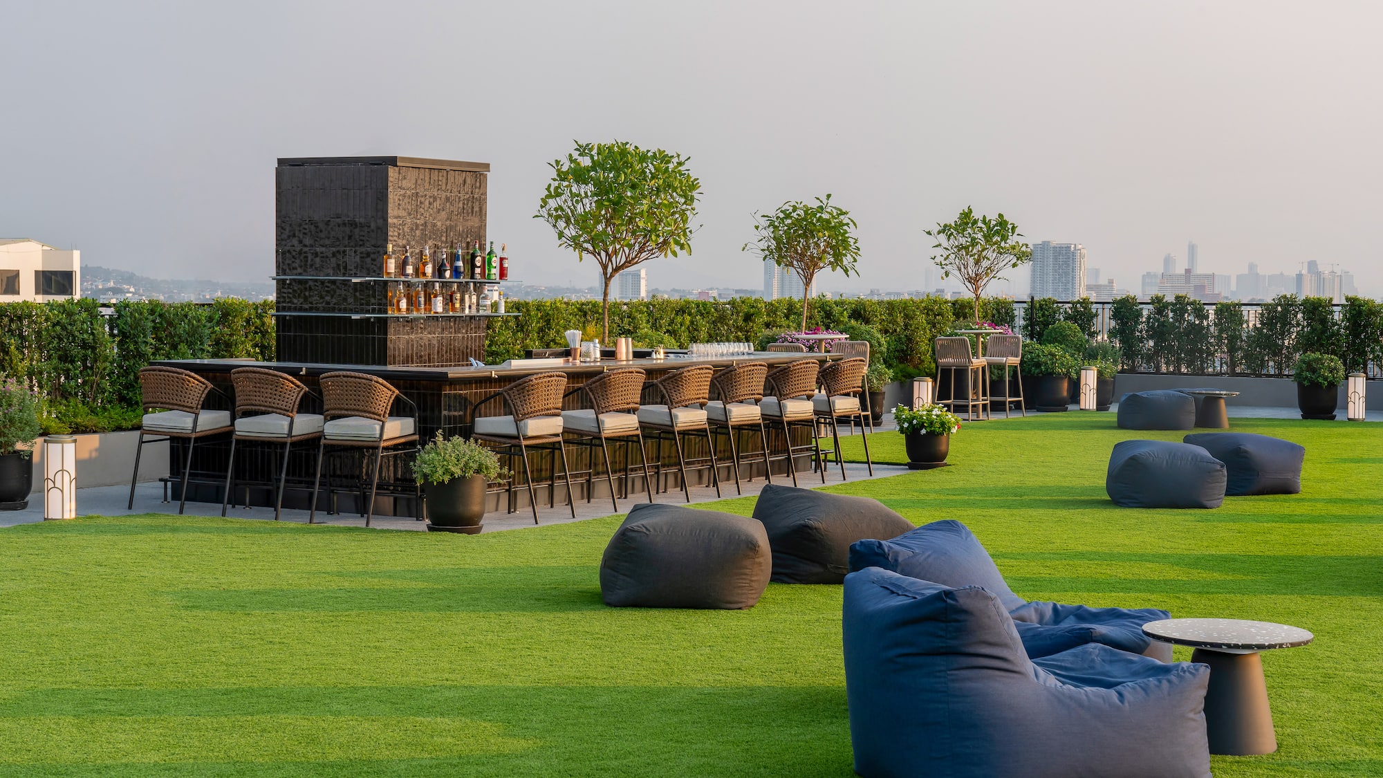 a group of chairs on a green lawn with a bar and a bench