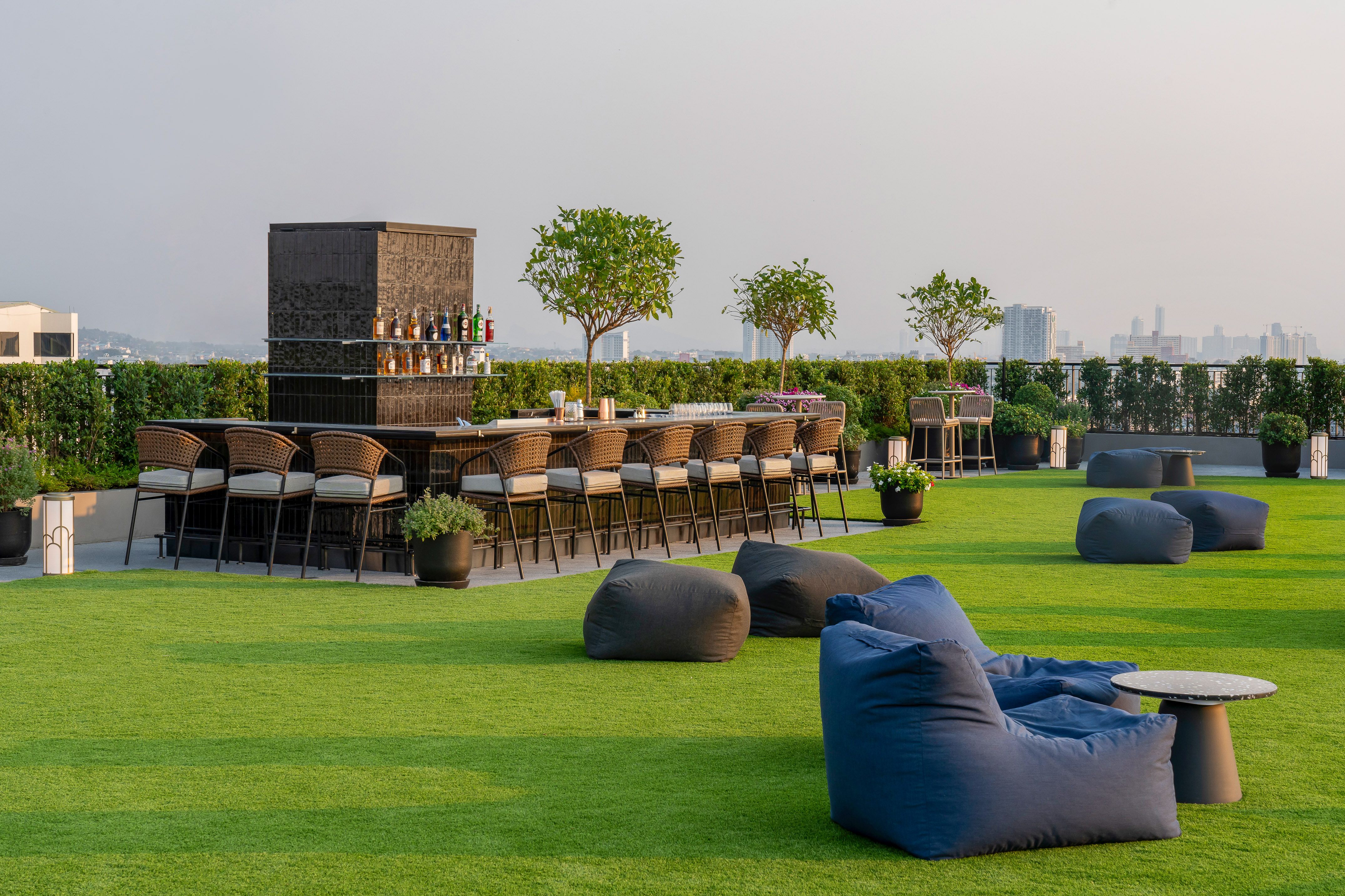 a group of chairs on a green lawn with a bar and a bench