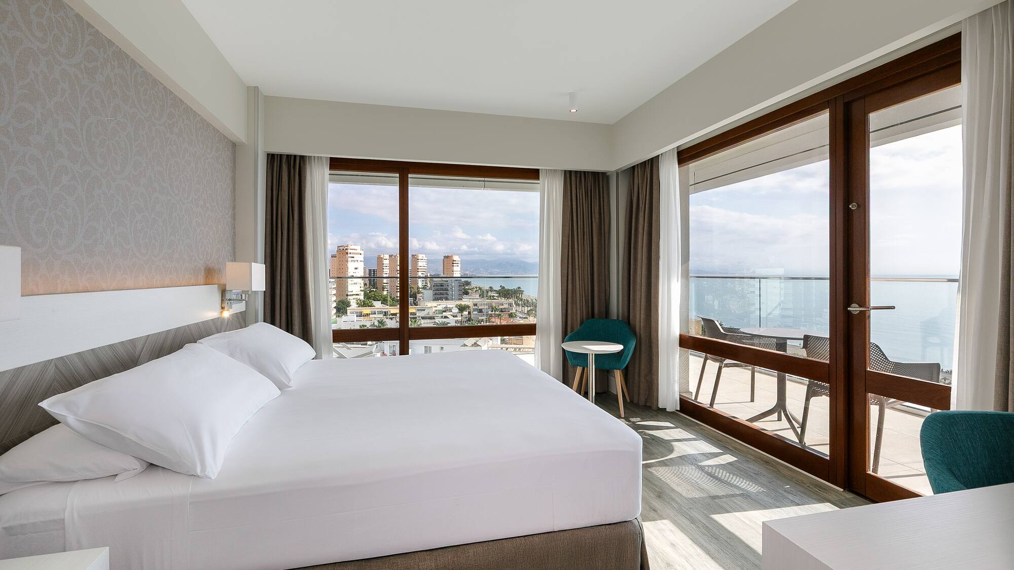 a bedroom with a large bed and a table and chairs