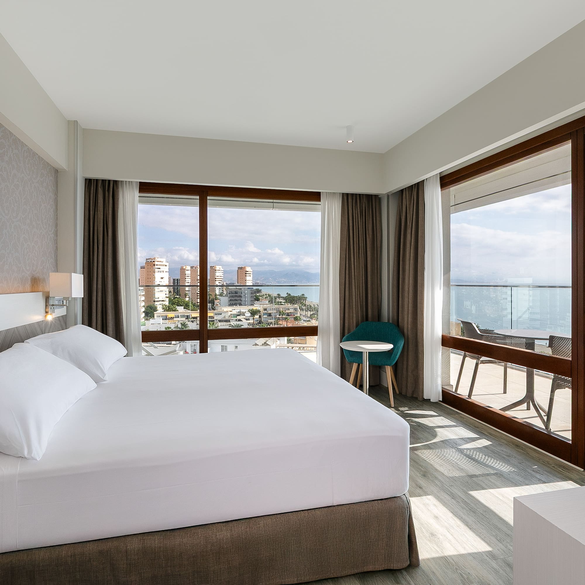 a bedroom with a large bed and a table and chairs