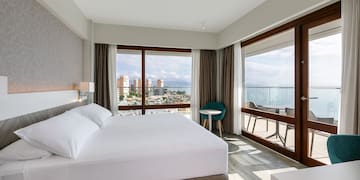 a bedroom with a large bed and a table and chairs