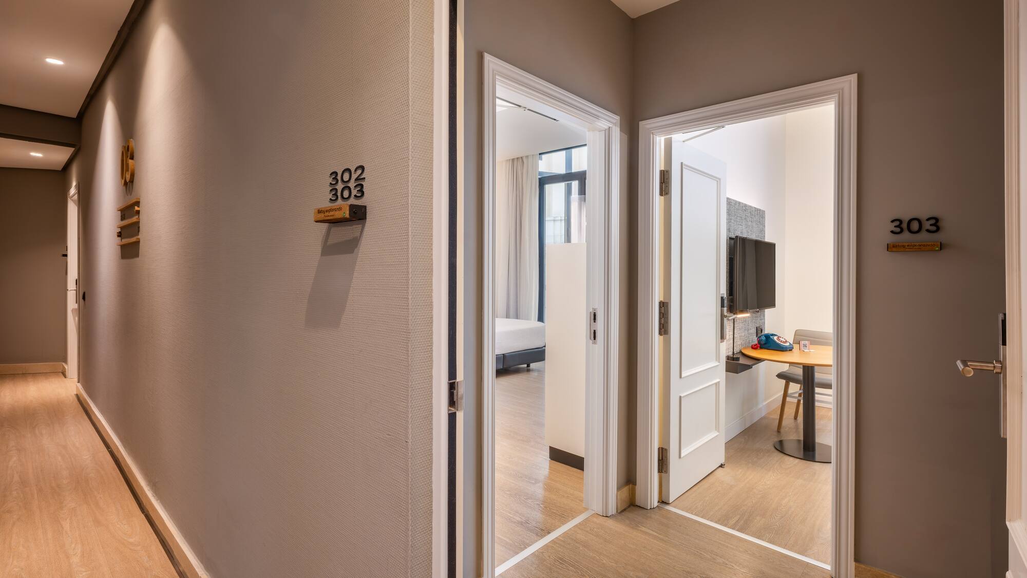 Modern hotel hallway with open doors to guest rooms 302 and 303.