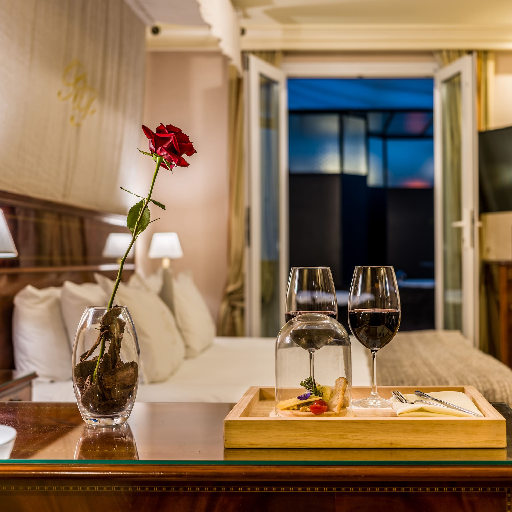 a table with wine glasses and a rose in it