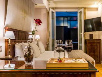 a table with wine glasses and a rose in it