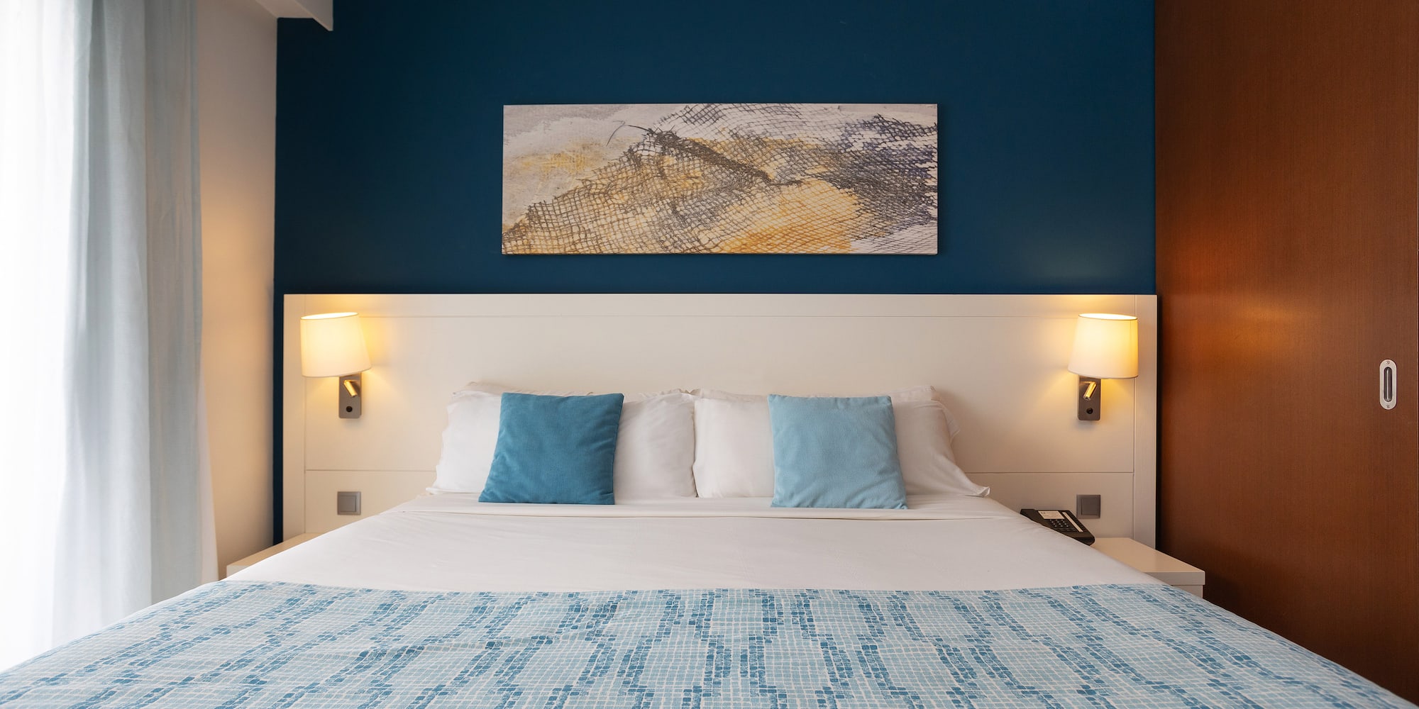 a bed with a blue and white blanket