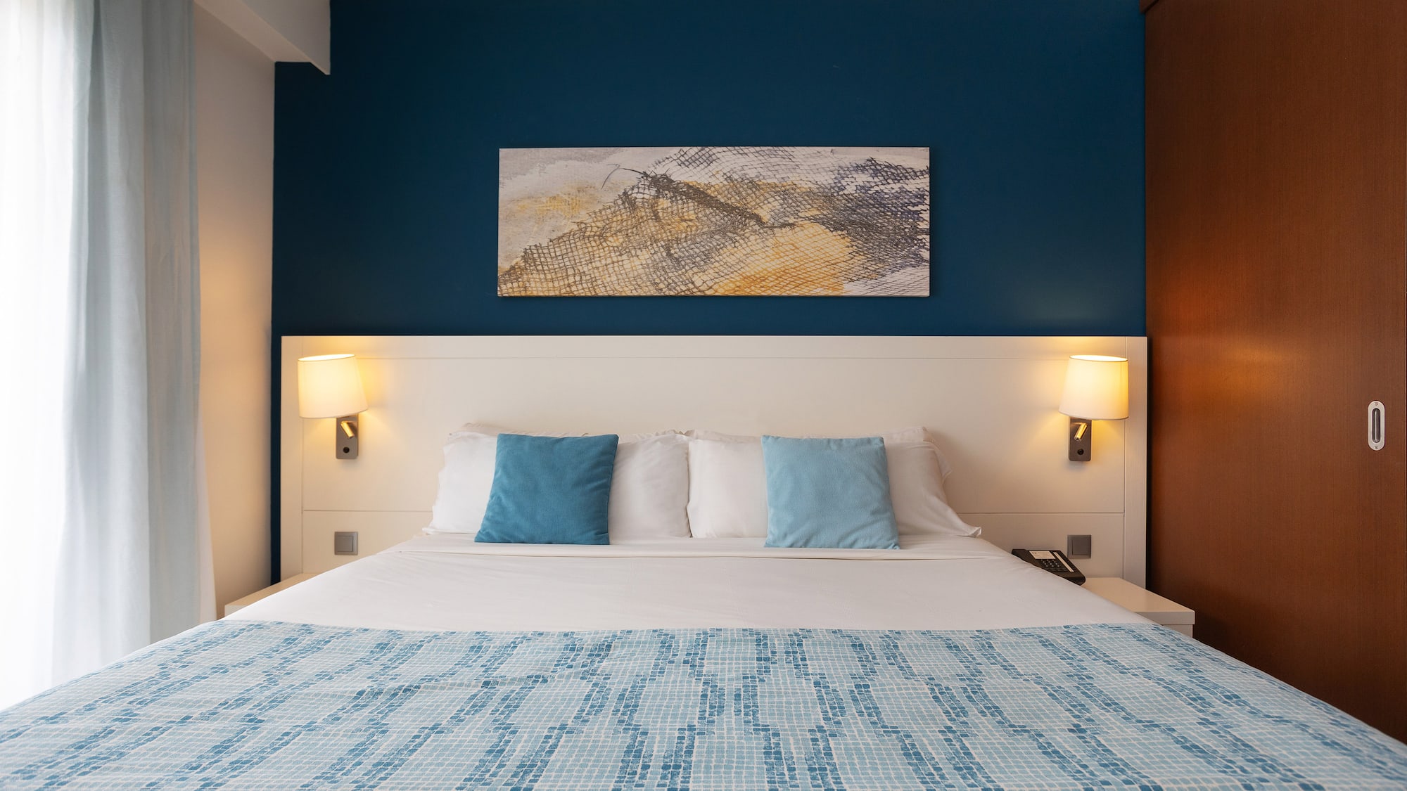 a bed with a blue and white blanket