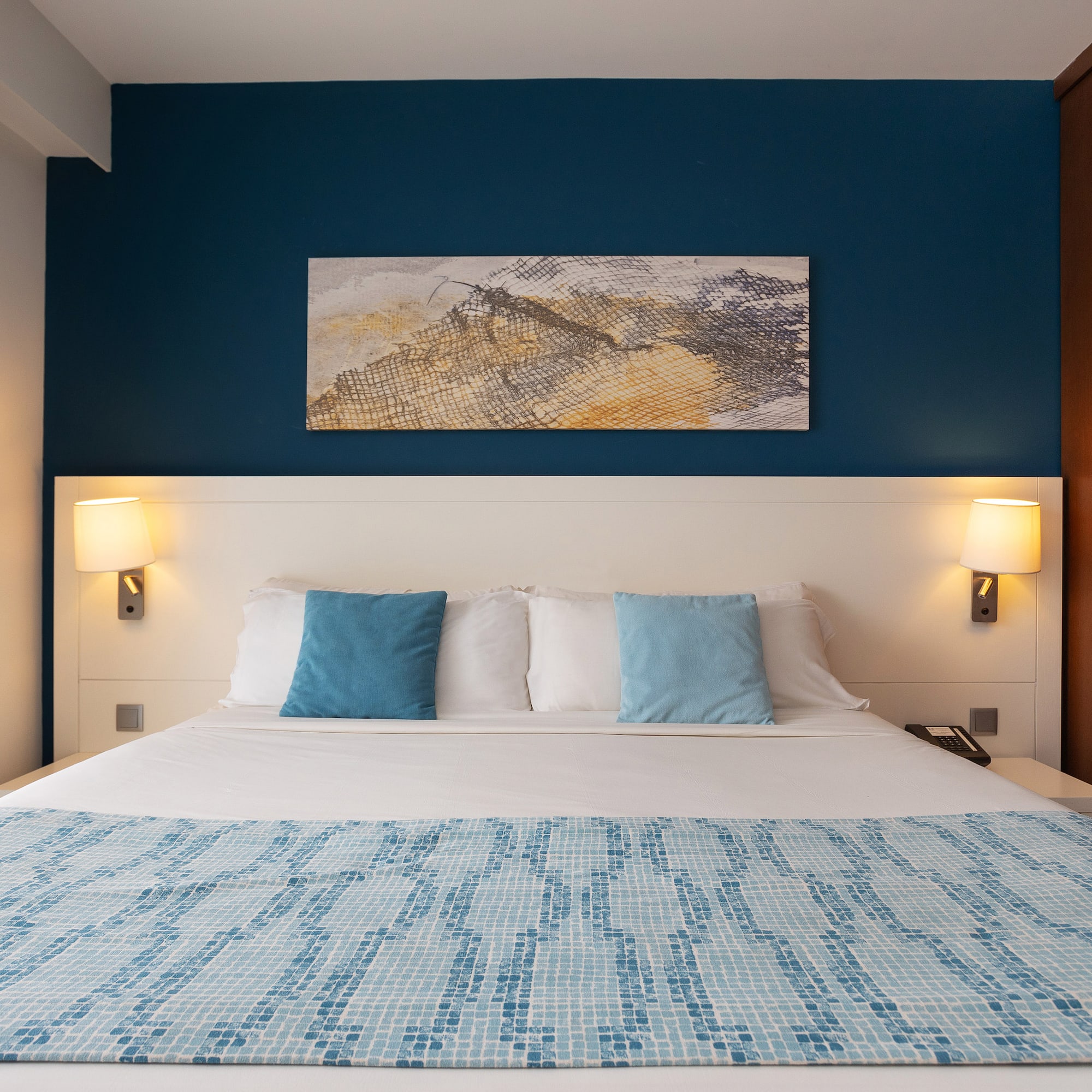 a bed with a blue and white blanket