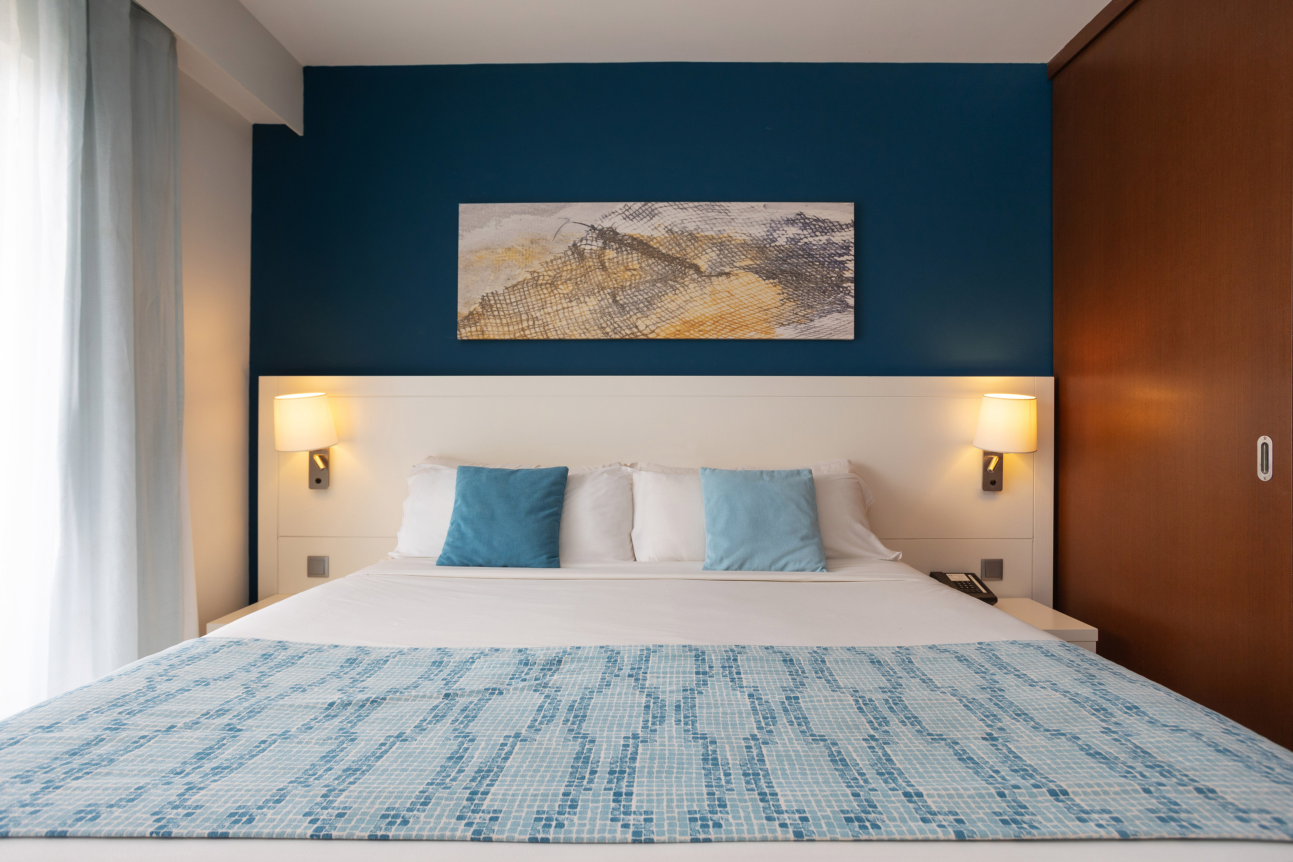 a bed with a blue and white blanket