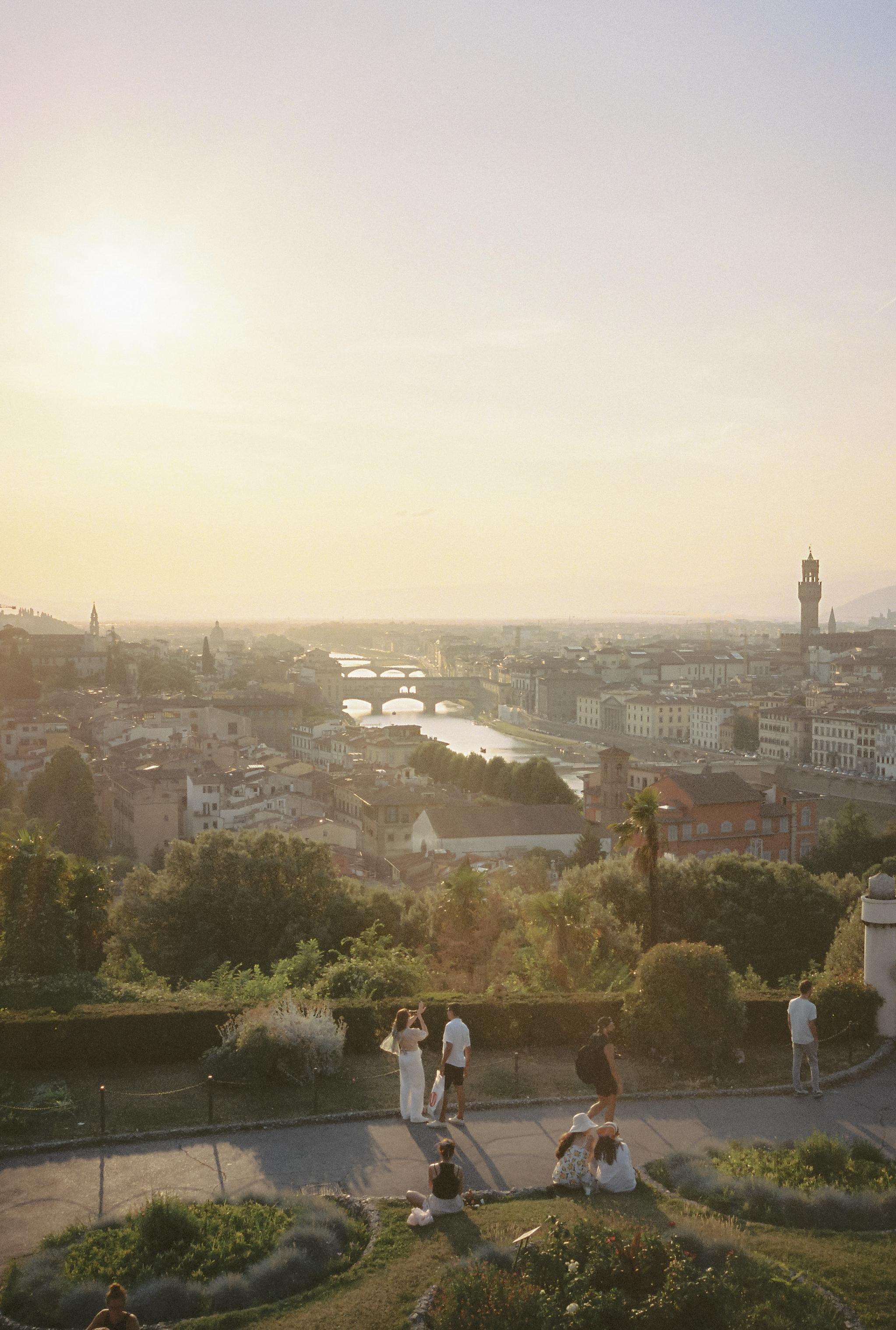 a group of people standing on a hill overlooking a city