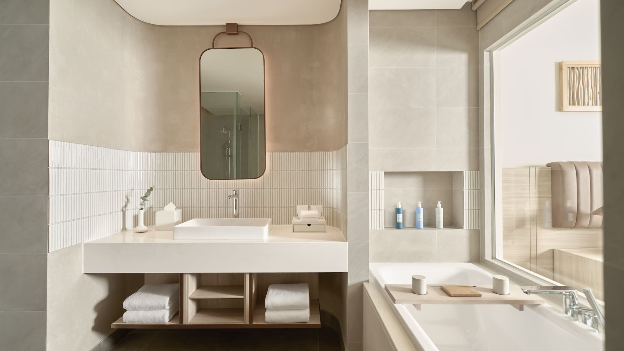 Minimalist modern bathroom design with neutral tones, floating vanity, and large bathtub.