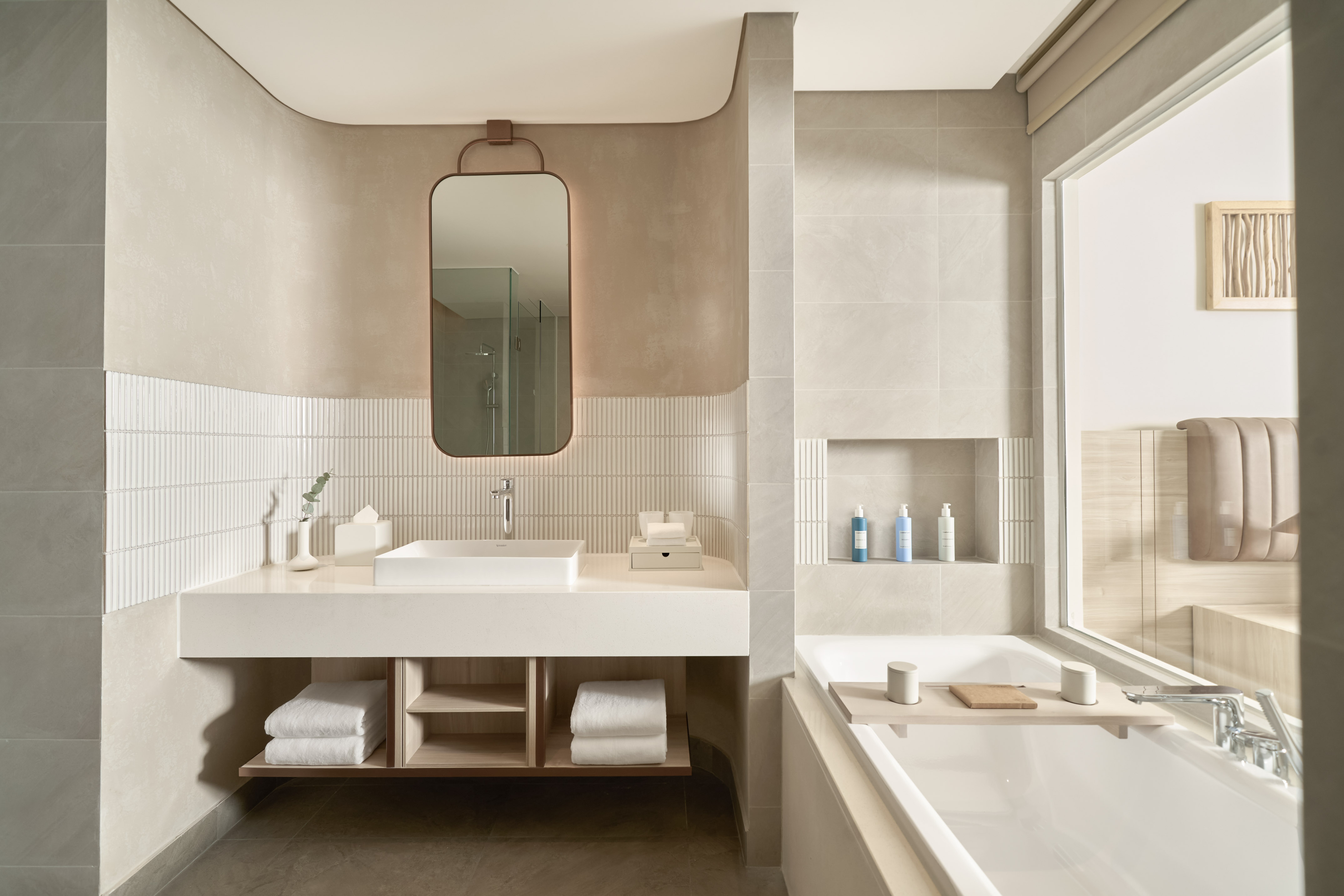 Minimalist modern bathroom design with neutral tones, floating vanity, and large bathtub.