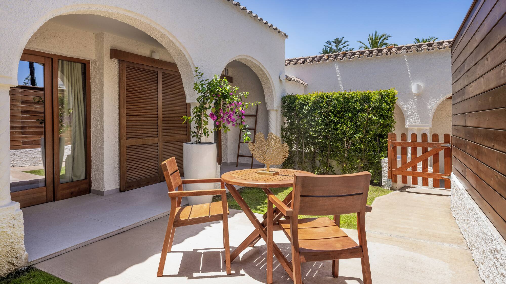 a patio with chairs and a table in front of a house