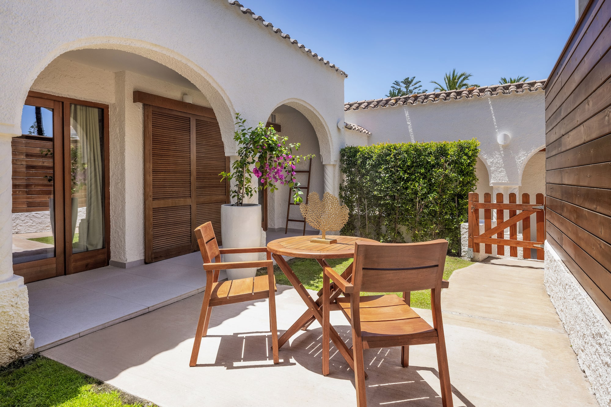 a patio with chairs and a table in front of a house