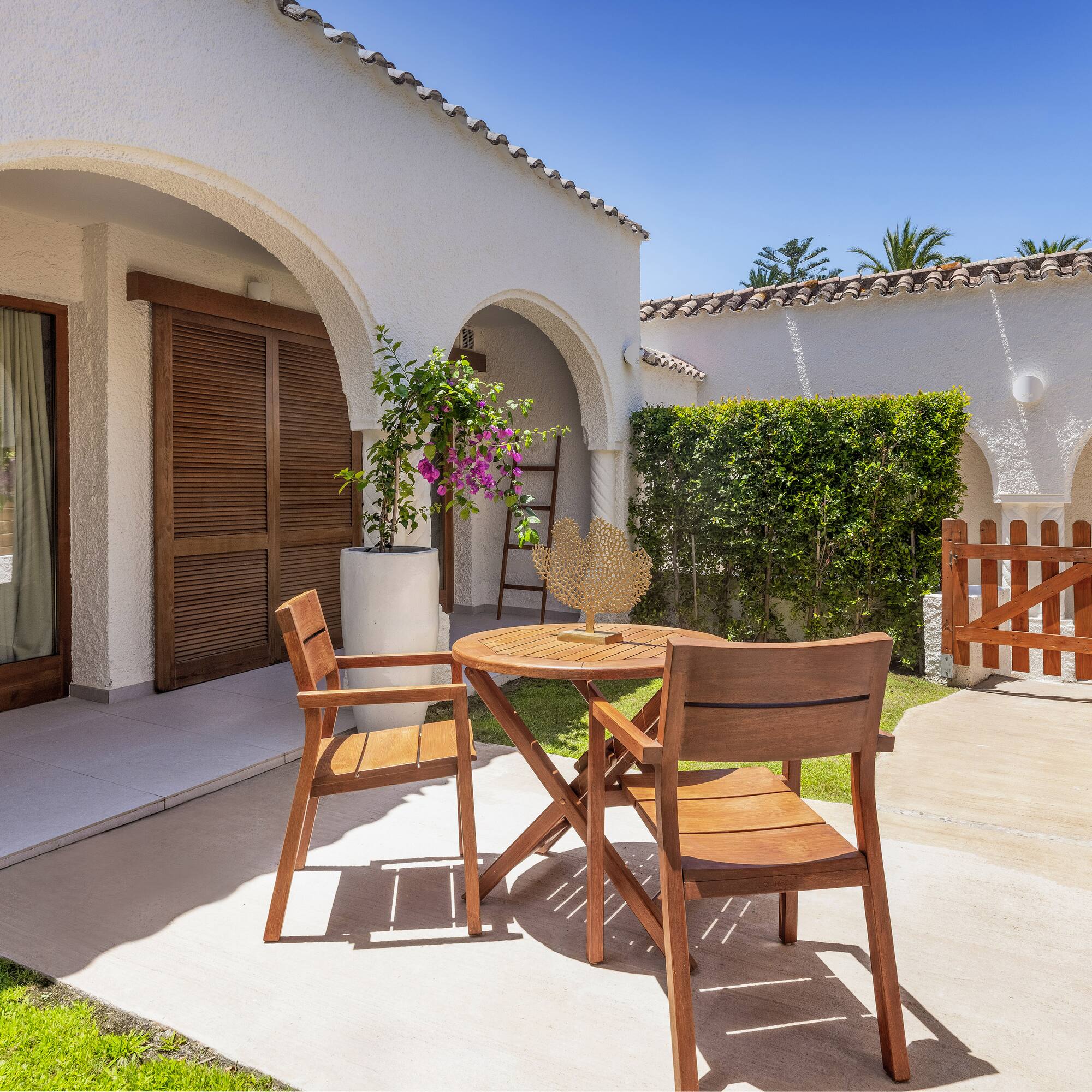 a patio with chairs and a table in front of a house