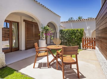 a patio with chairs and a table in front of a house
