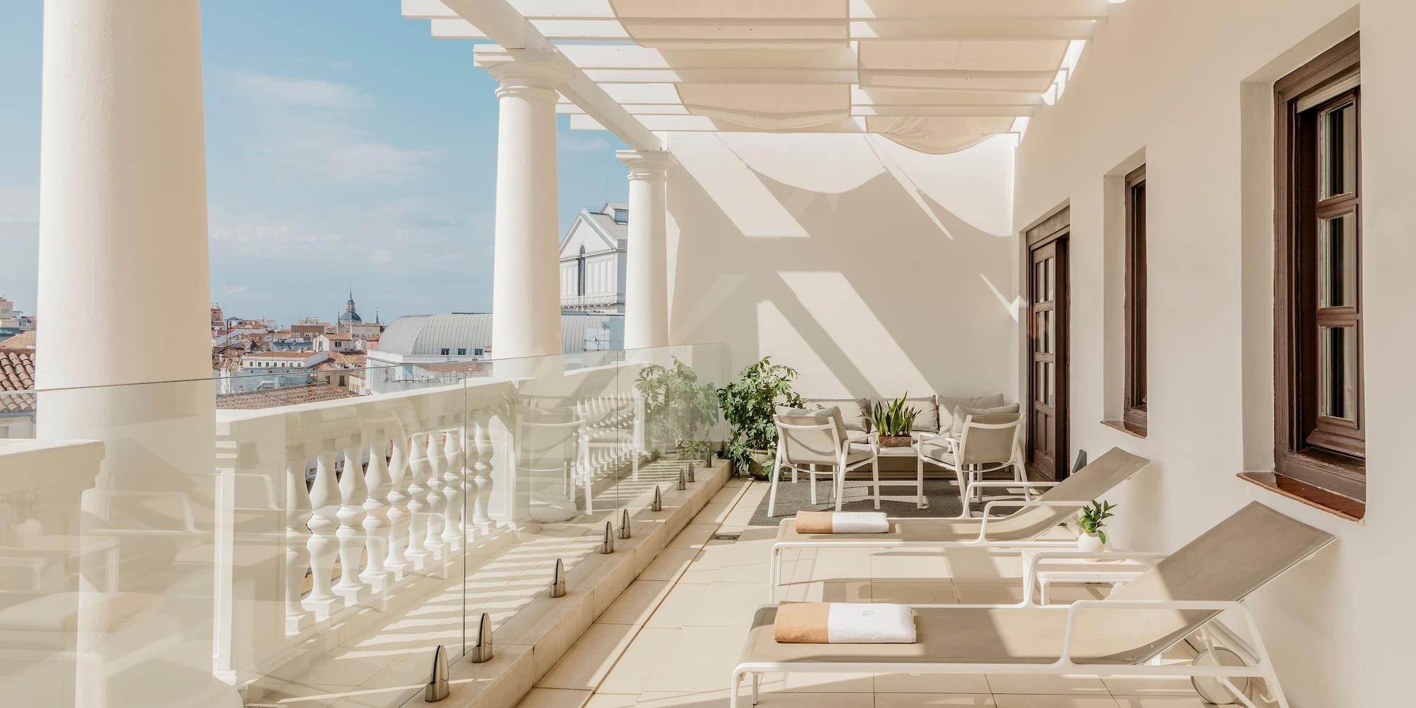 a patio with chairs and a white railing