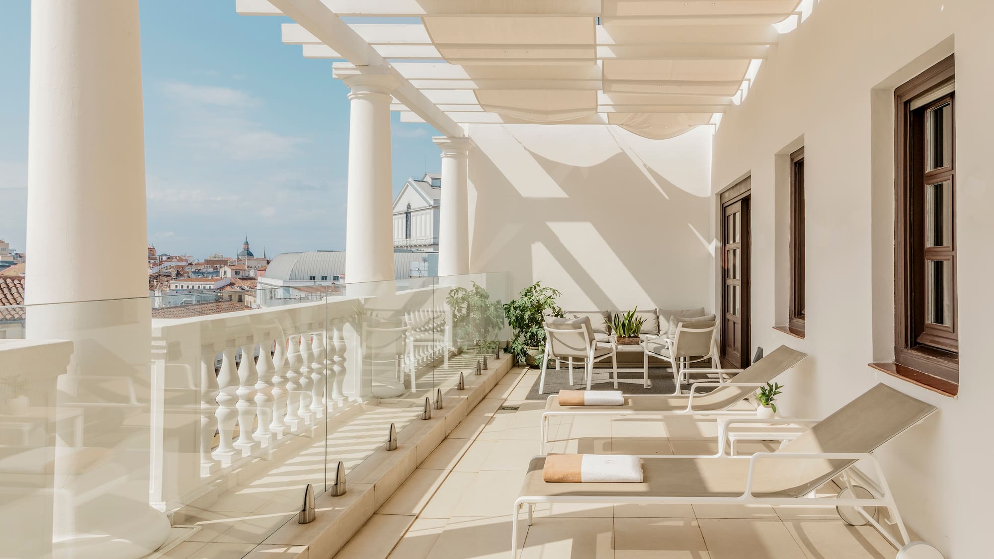 a patio with chairs and a white railing