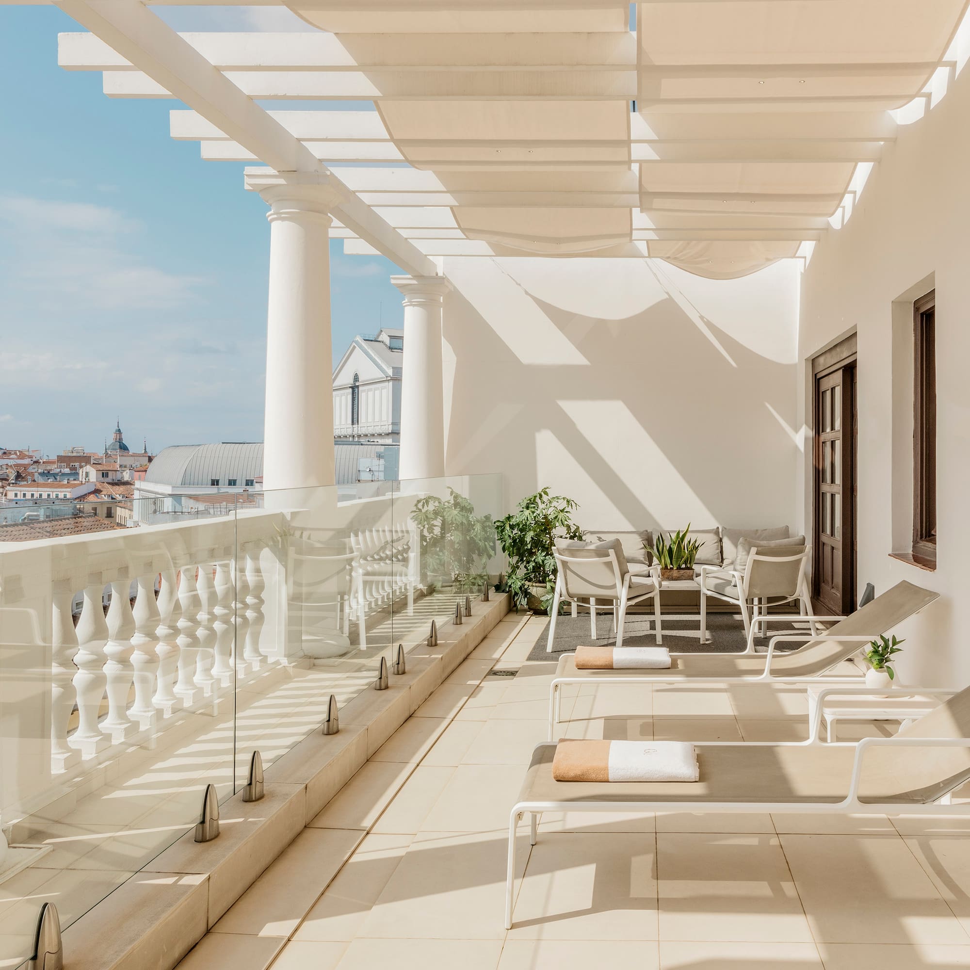 a patio with chairs and a white railing