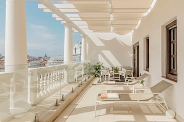 a patio with chairs and a white railing
