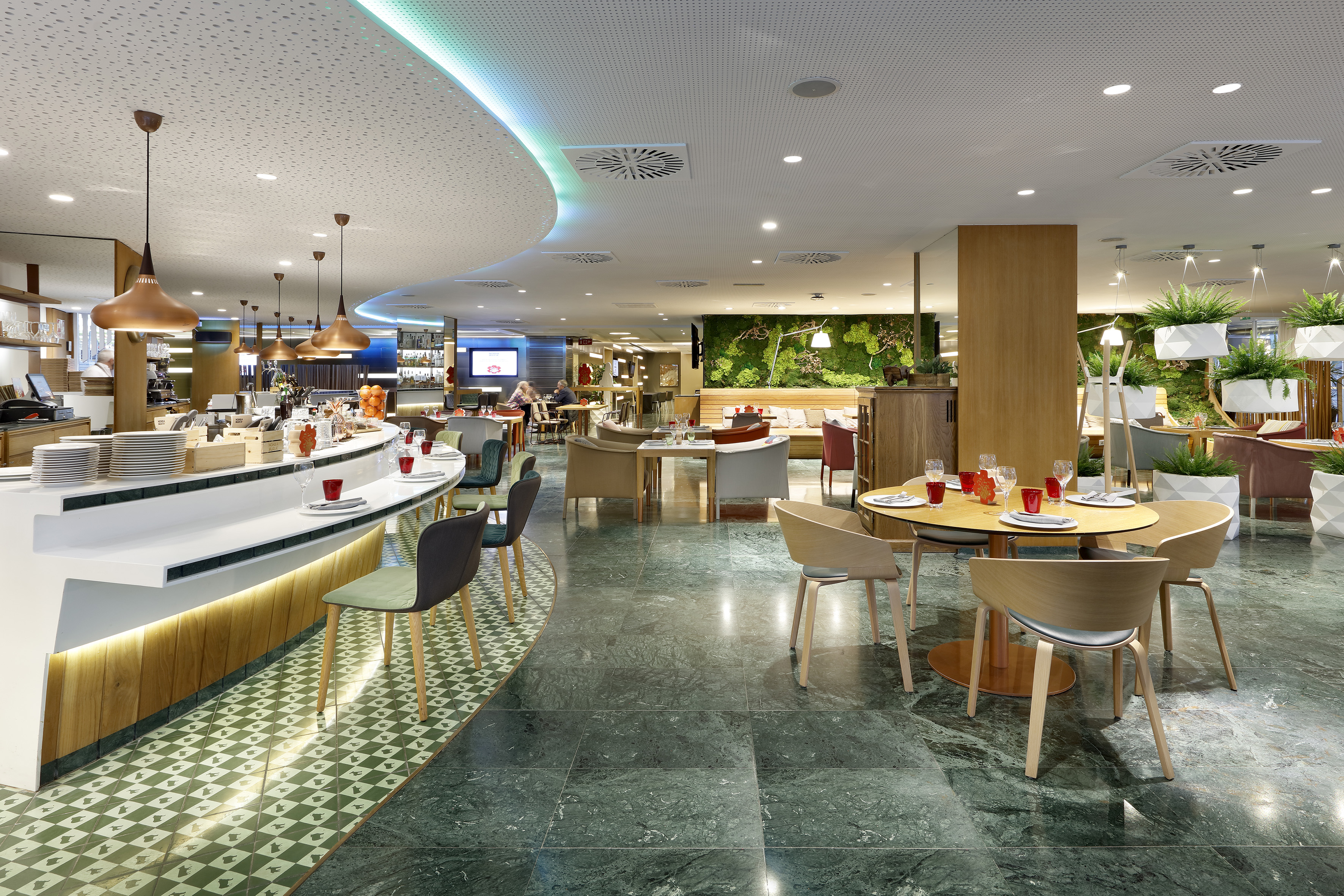 Modern hotel restaurant interior with bar, green wall, and marble floor.