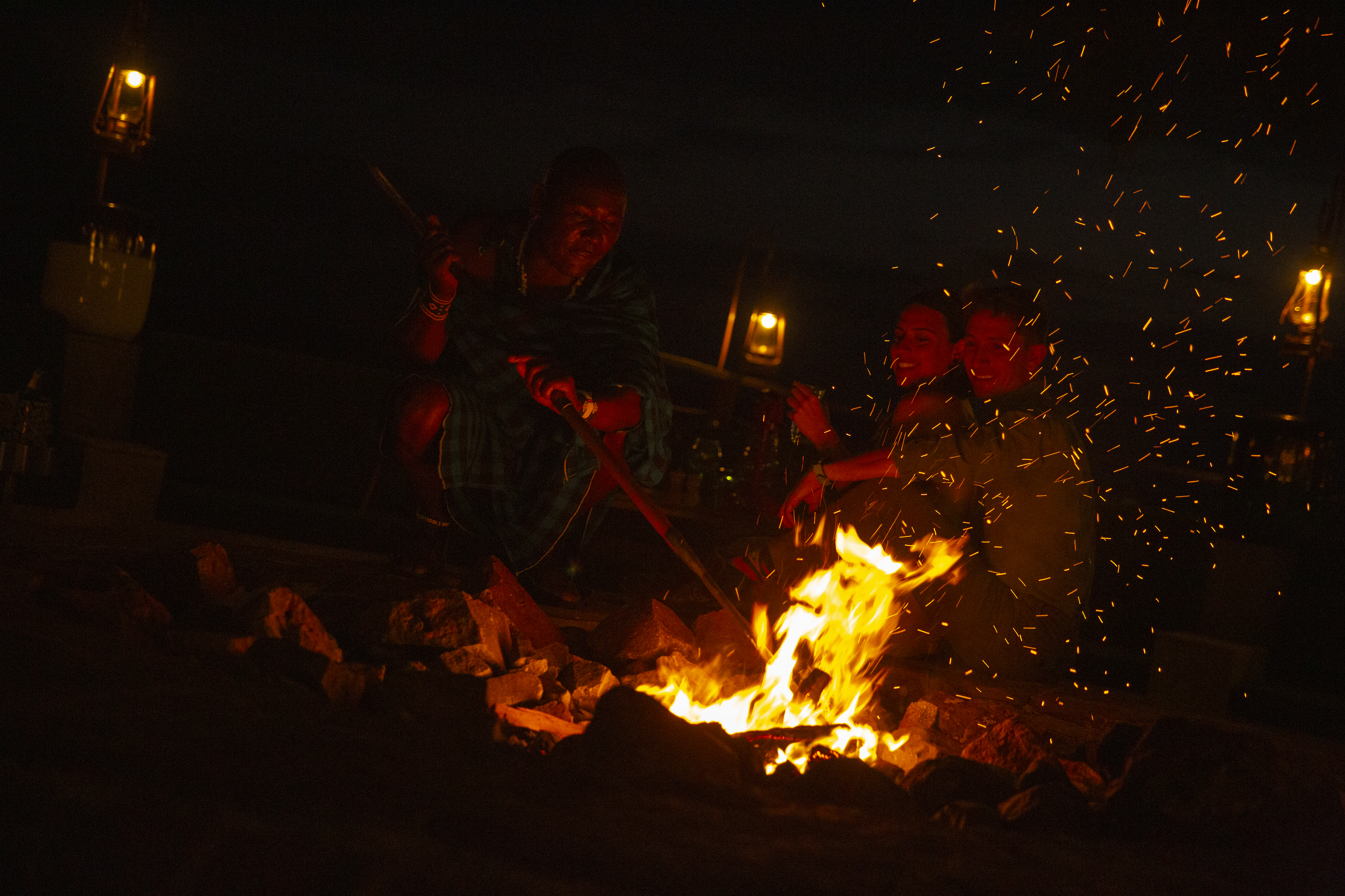 a group of people sitting around a fire