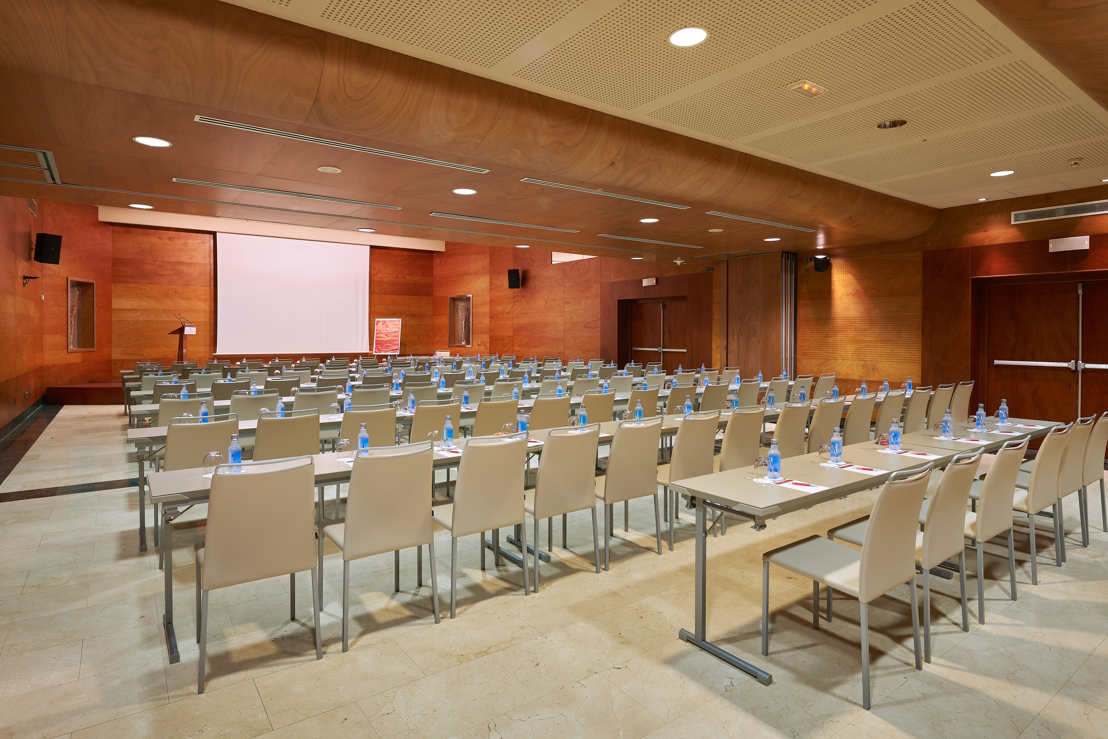 Modern conference room setup with tables, chairs, large screen, and wood paneling. - Principado C - Palacio de Avilés Afiliat Meliá, Avilés